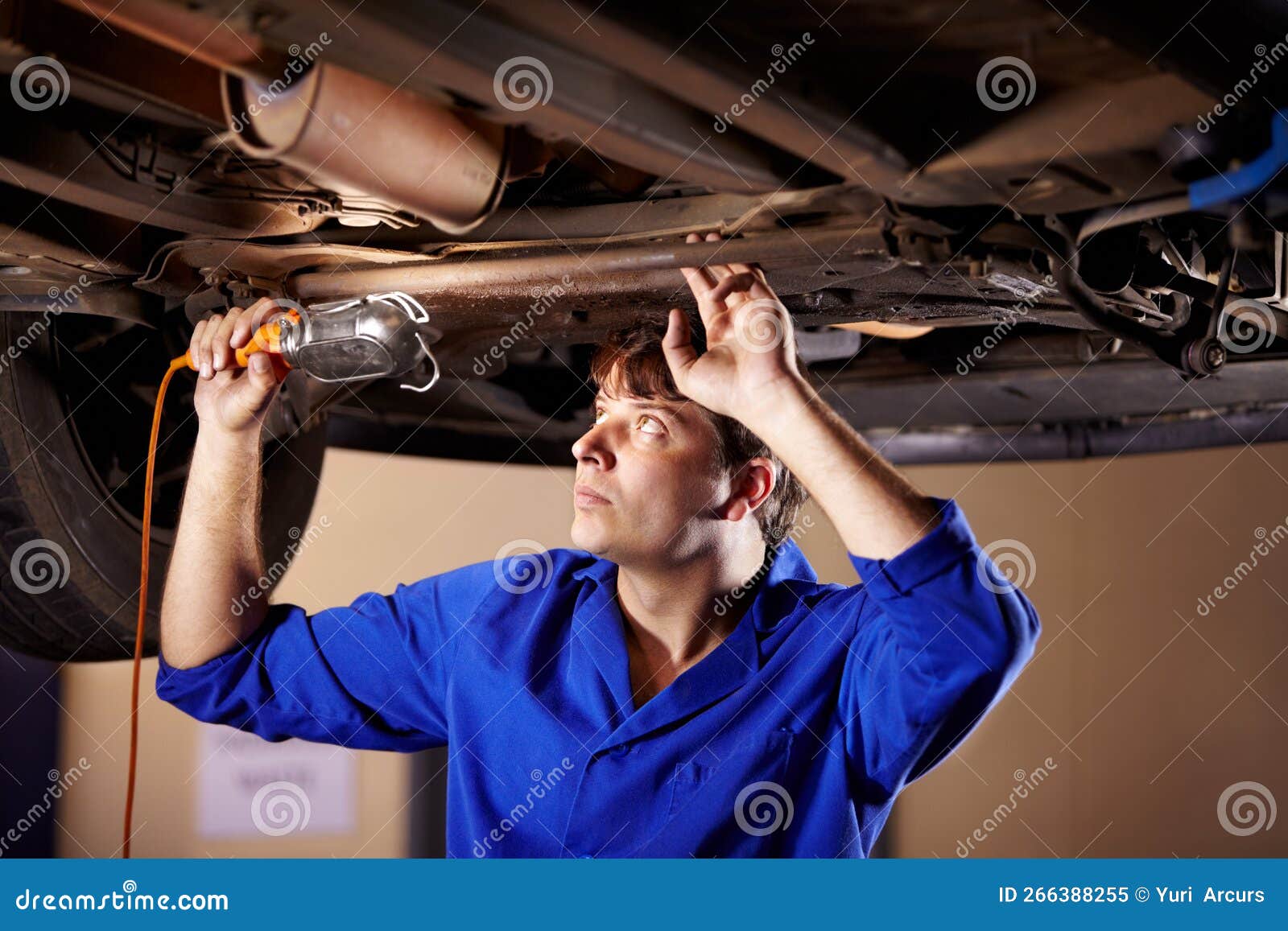 Obtenir Un Meilleur Look. Un Jeune Mécanicien Qui Regarde Sous Une Voiture  Avec Une Lumière. Image stock - Image du compétence, gens: 266388255