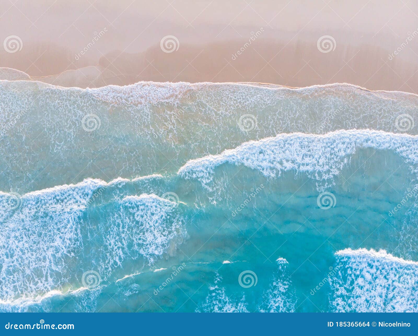 ocean beach aerial top down view with blue water, waves with foam and spray and fine sand, beautiful summer vacation holidays