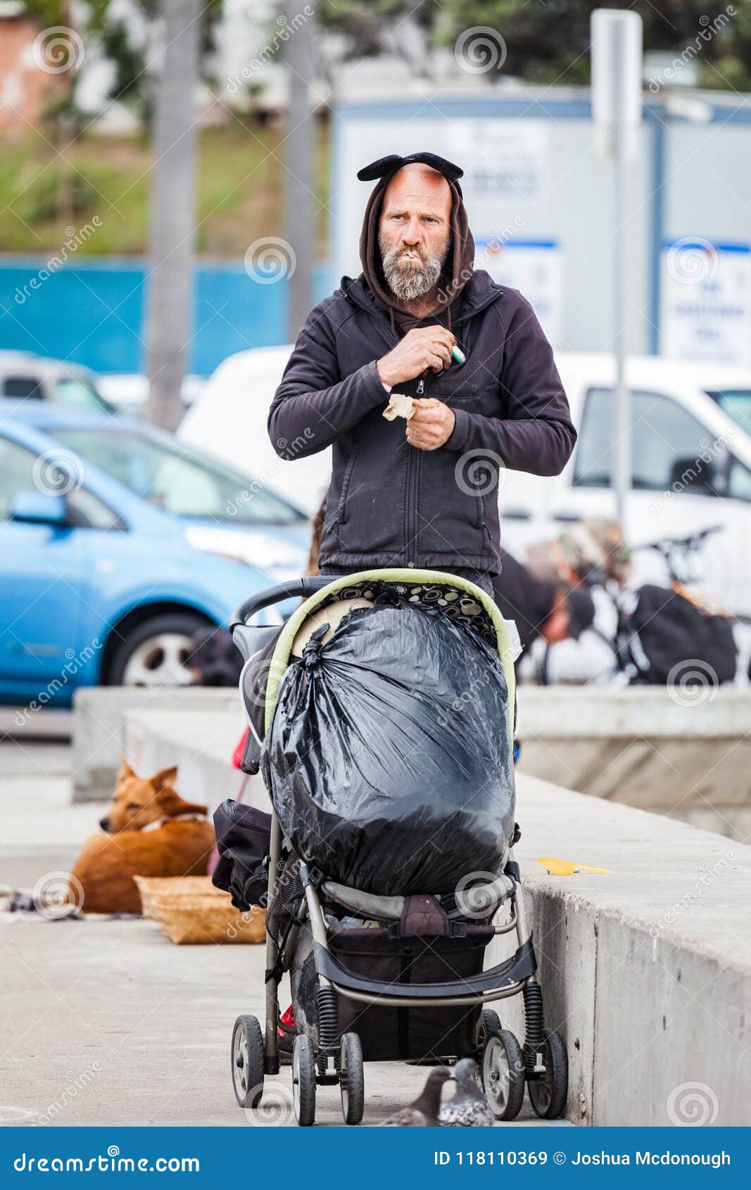 ocean-beach-san-diego-california-usa-may-homeless-man-lites-up-cigarette-pushing-his-belongings-old-stroller-along-118110369.jpg