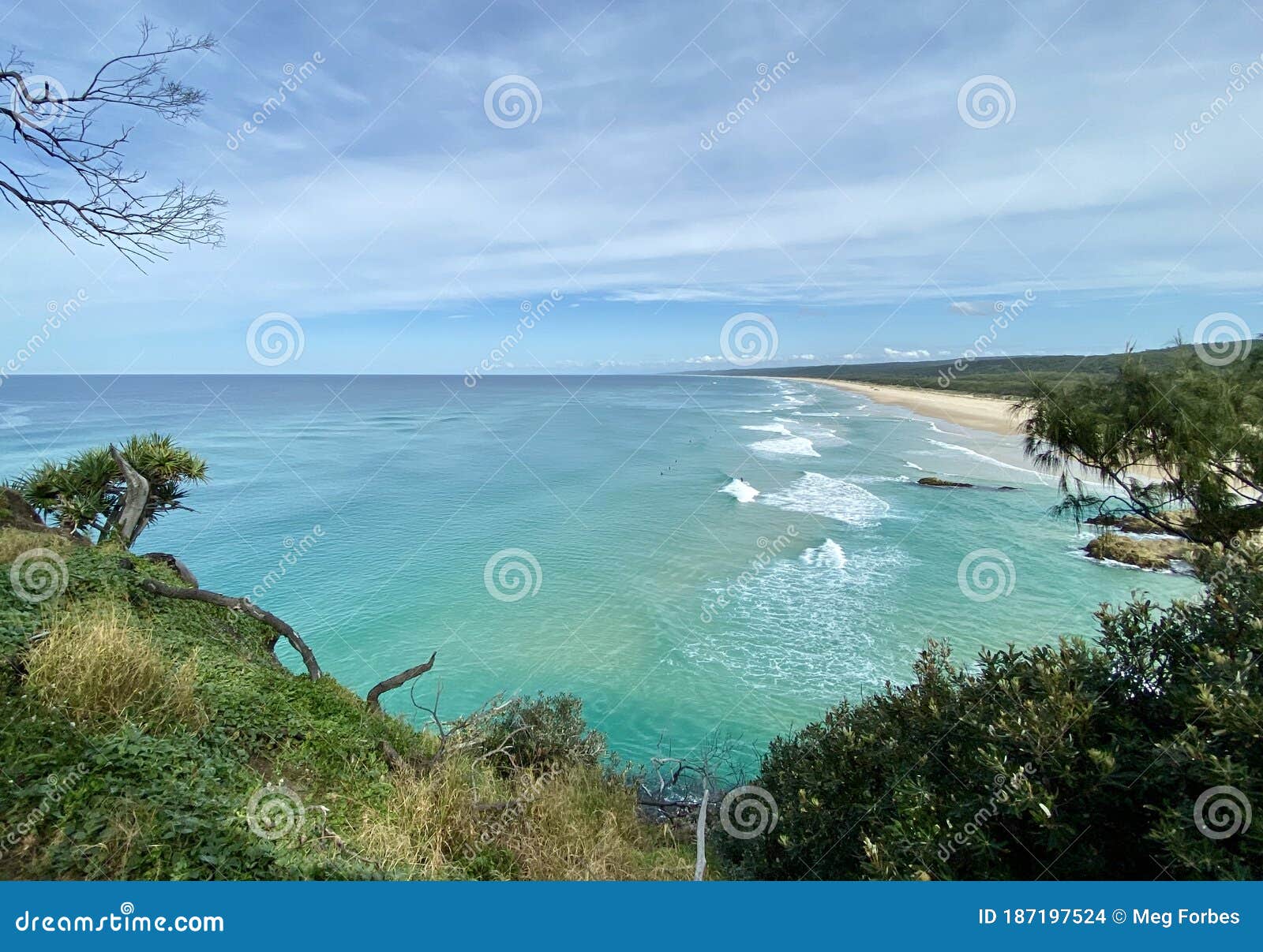 ocean views and a surf beach taken from a rocky headland on a tropical island paradise off queensland, australia