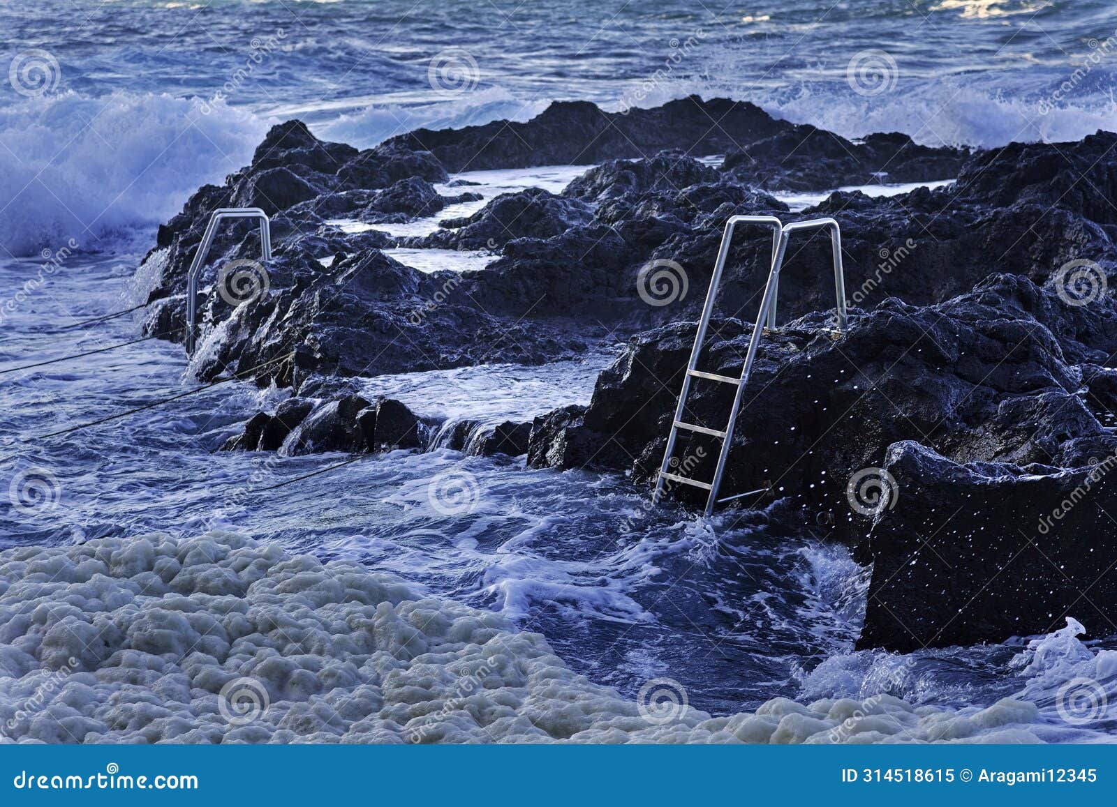 ocean waves and stairs in public pool of termas da ferraria