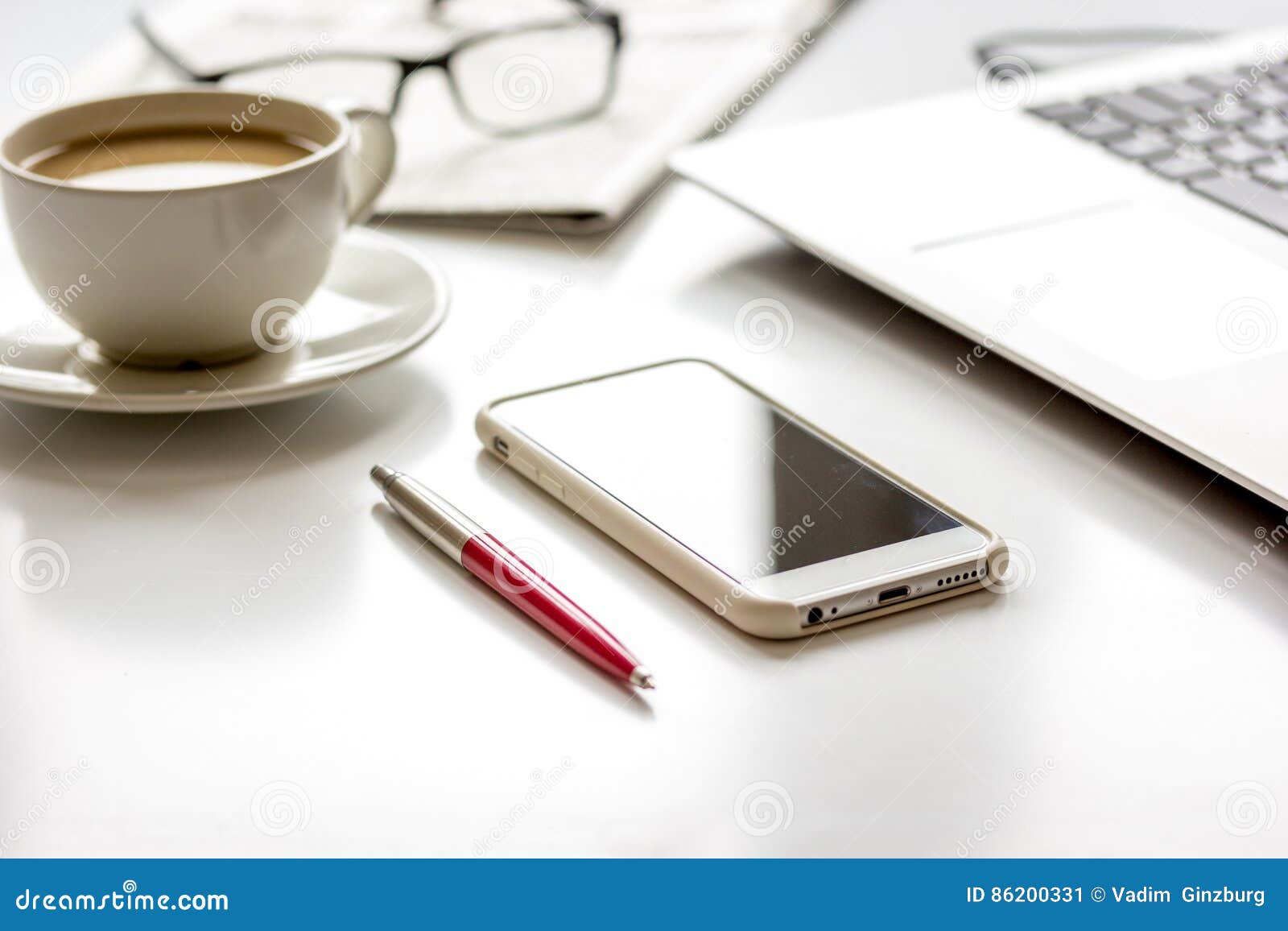 office breakfast with coffee, phone and laptop on white desk