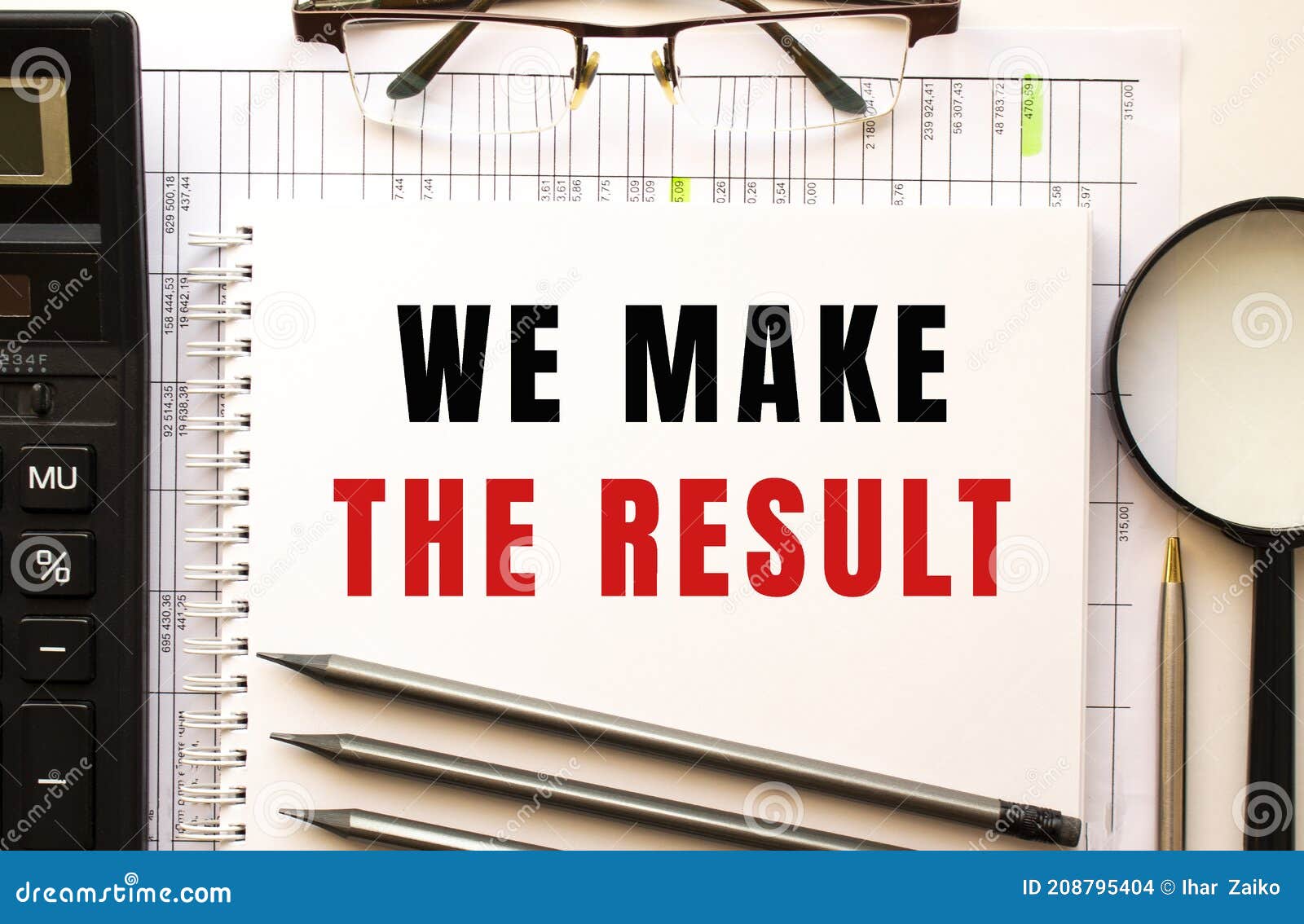 office desk with financial papers, calculator, glasses. notepad with the text we make the result