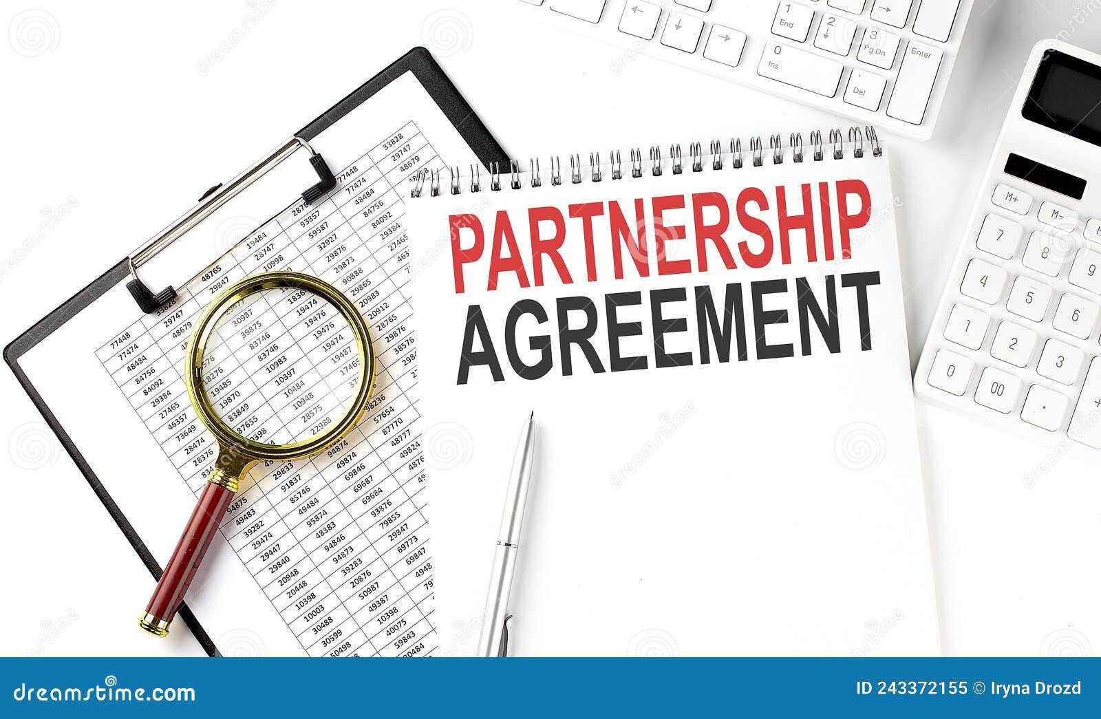 office desk table with keyboard, notepad ,chart and calculator. top view with text partnership agreement