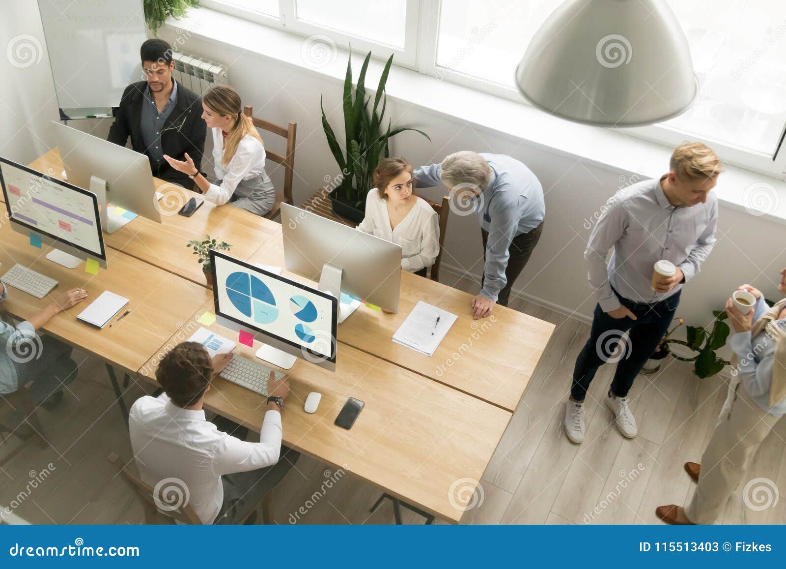 office employees working together sharing desk using computers i