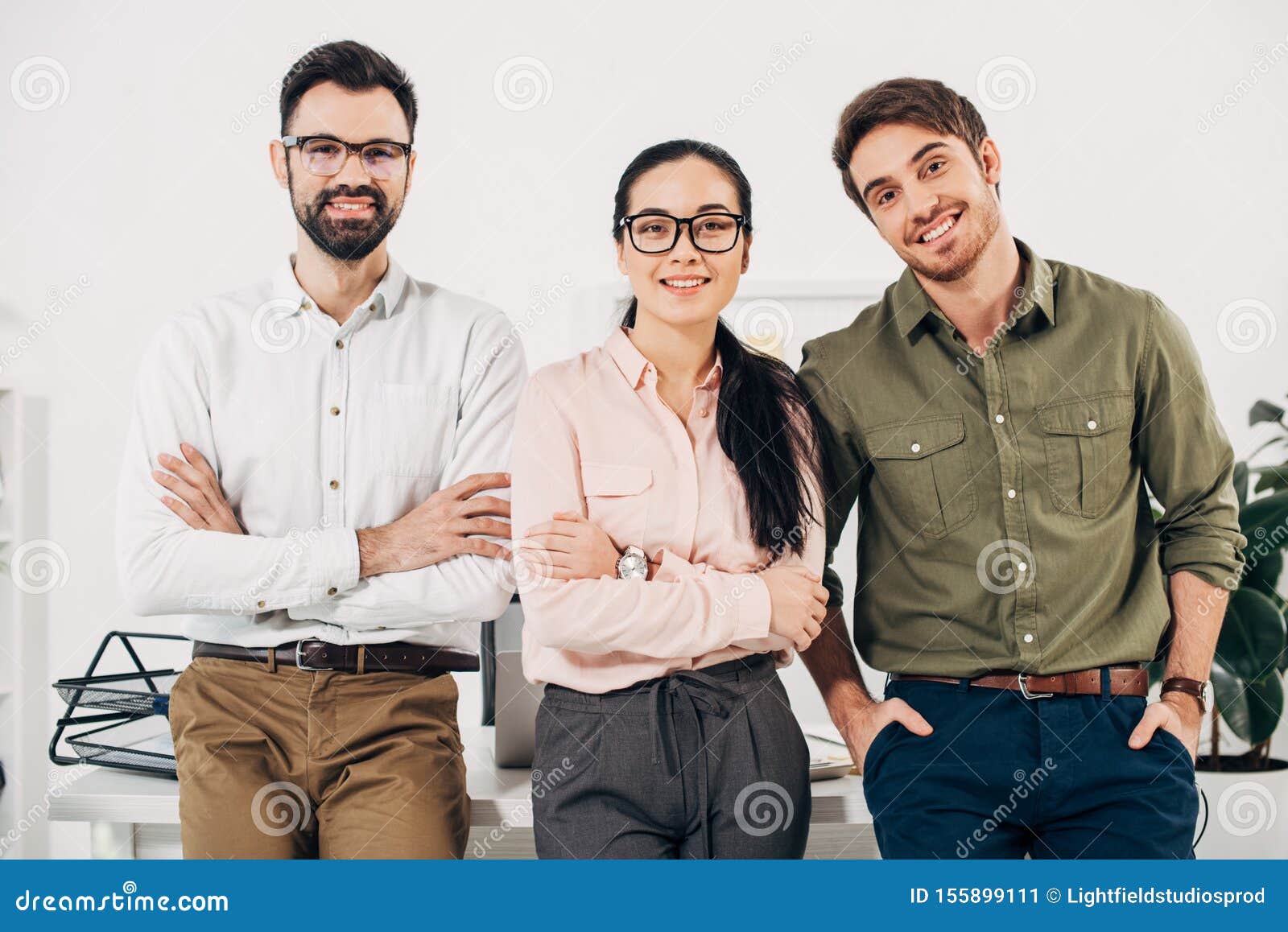 office managers with arms crossed smiling and looking at camera