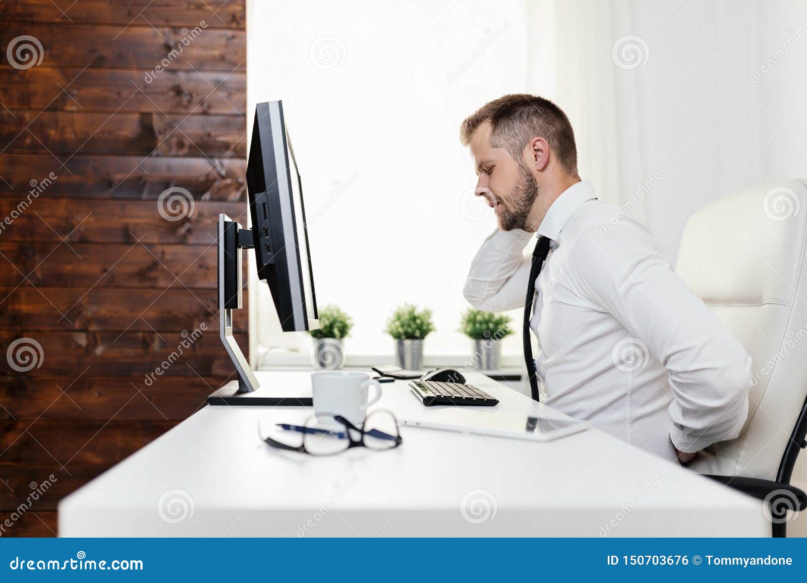 Office Worker With Pain From Sitting At Desk All Day Stock Photo