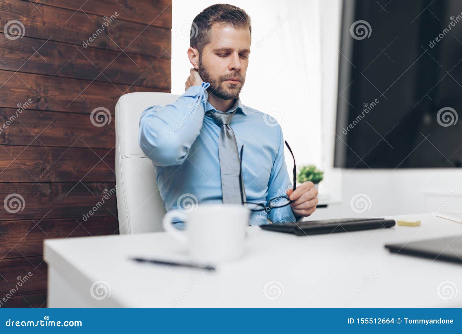 Office Worker With Pain From Sitting At Desk All Day Stock Photo