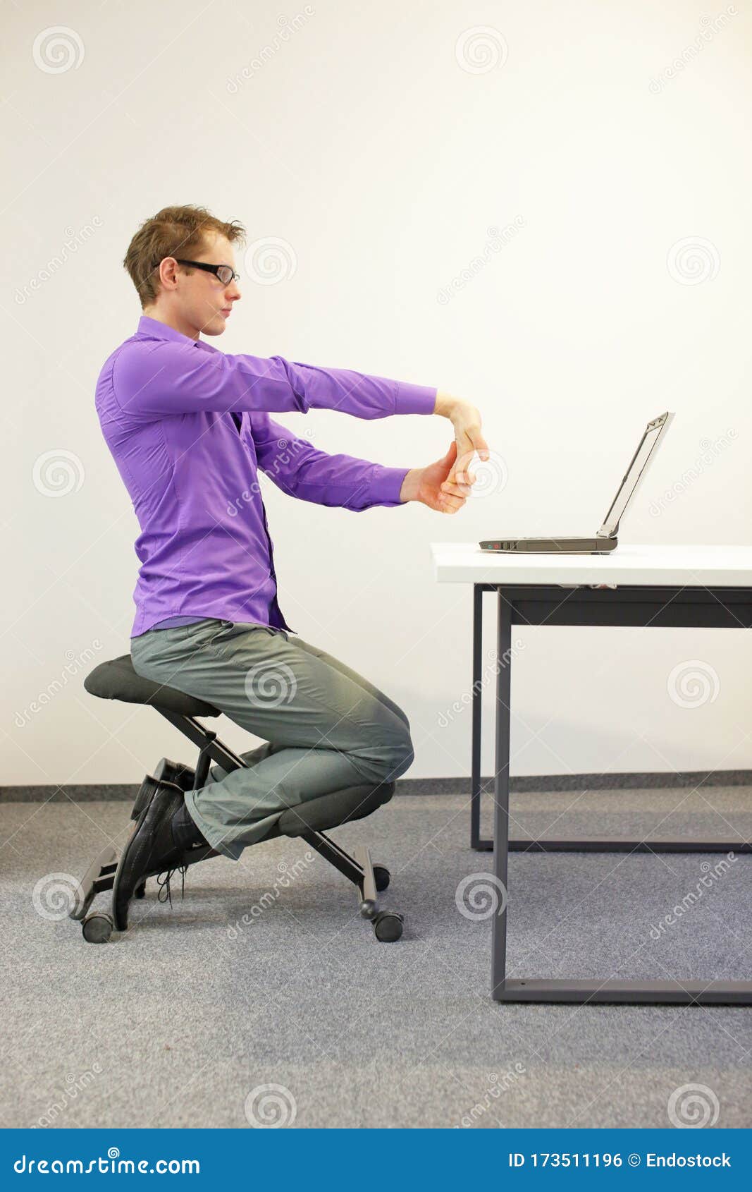 Office Worker Sitting on Kneeling Stool, Exercising during Short Break