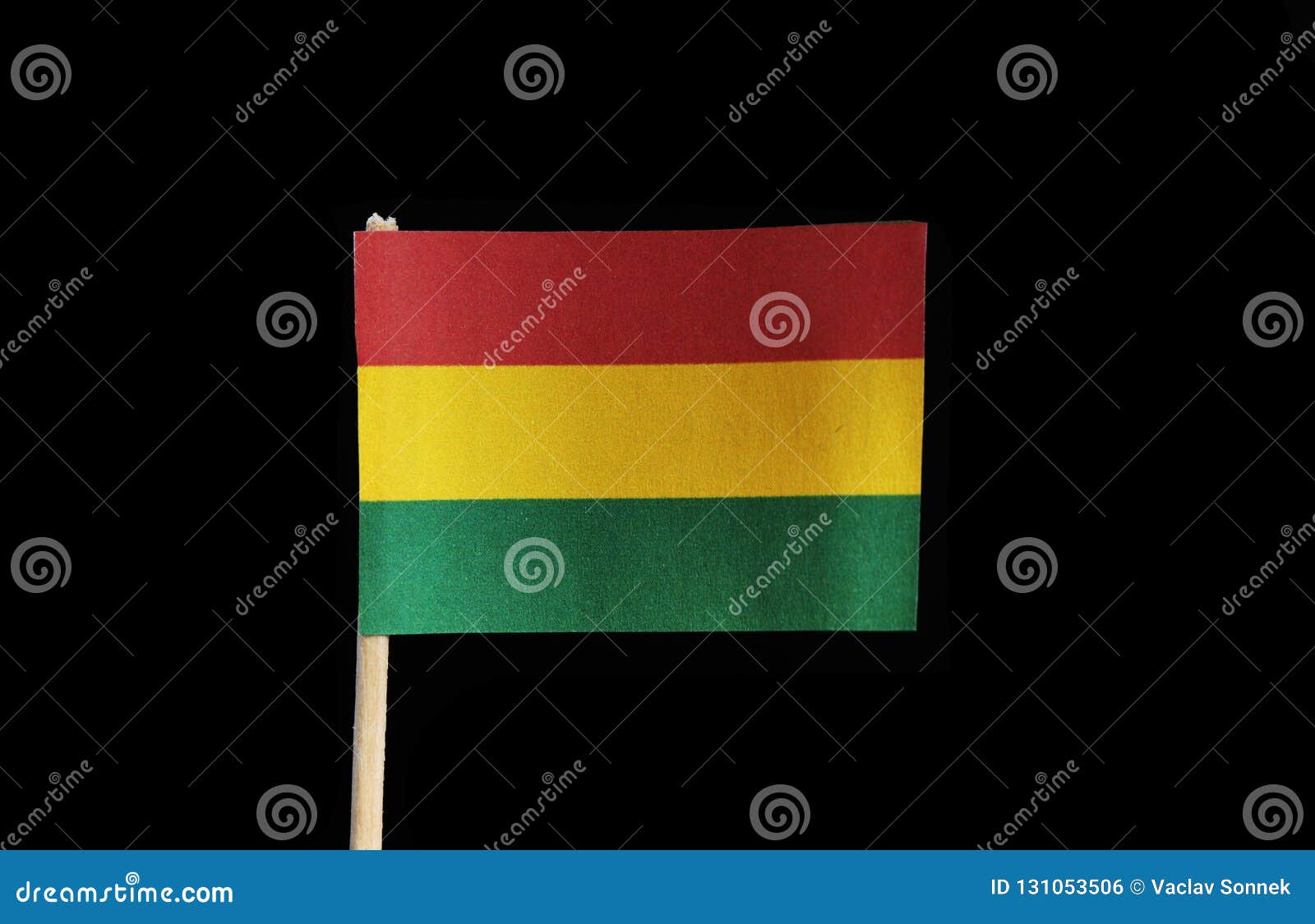 a official flag of bolivia on toothpick on black background. a horizontal tricolor of red, yellow and green with the national coa