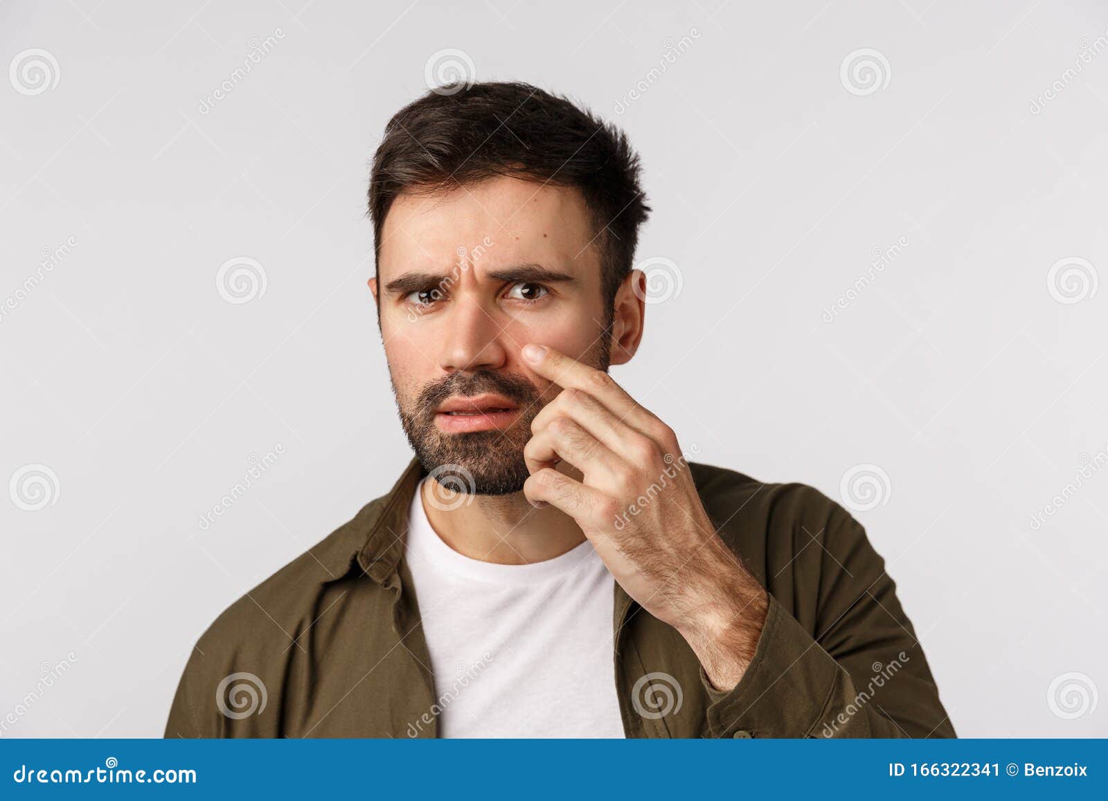oh my god is that wrinkle, acne. frustrated and alarmed displeased handsome bearded man touching his face and examine