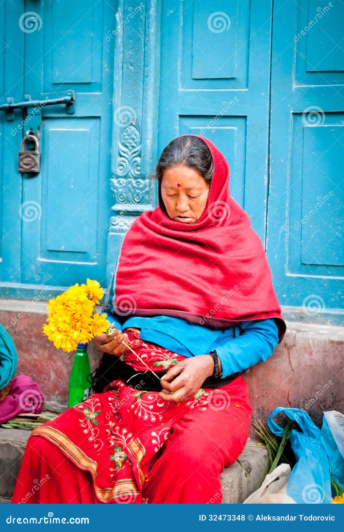 Oidentifierad blommaförsäljare i Katmandu, Nepal. Oidentifierad blommaförsäljare på blommamarknaden i Katmandu, Nepal. Denna är en liten marknad för återförsäljnings- blomsterhandlare och gatuförsäljare.