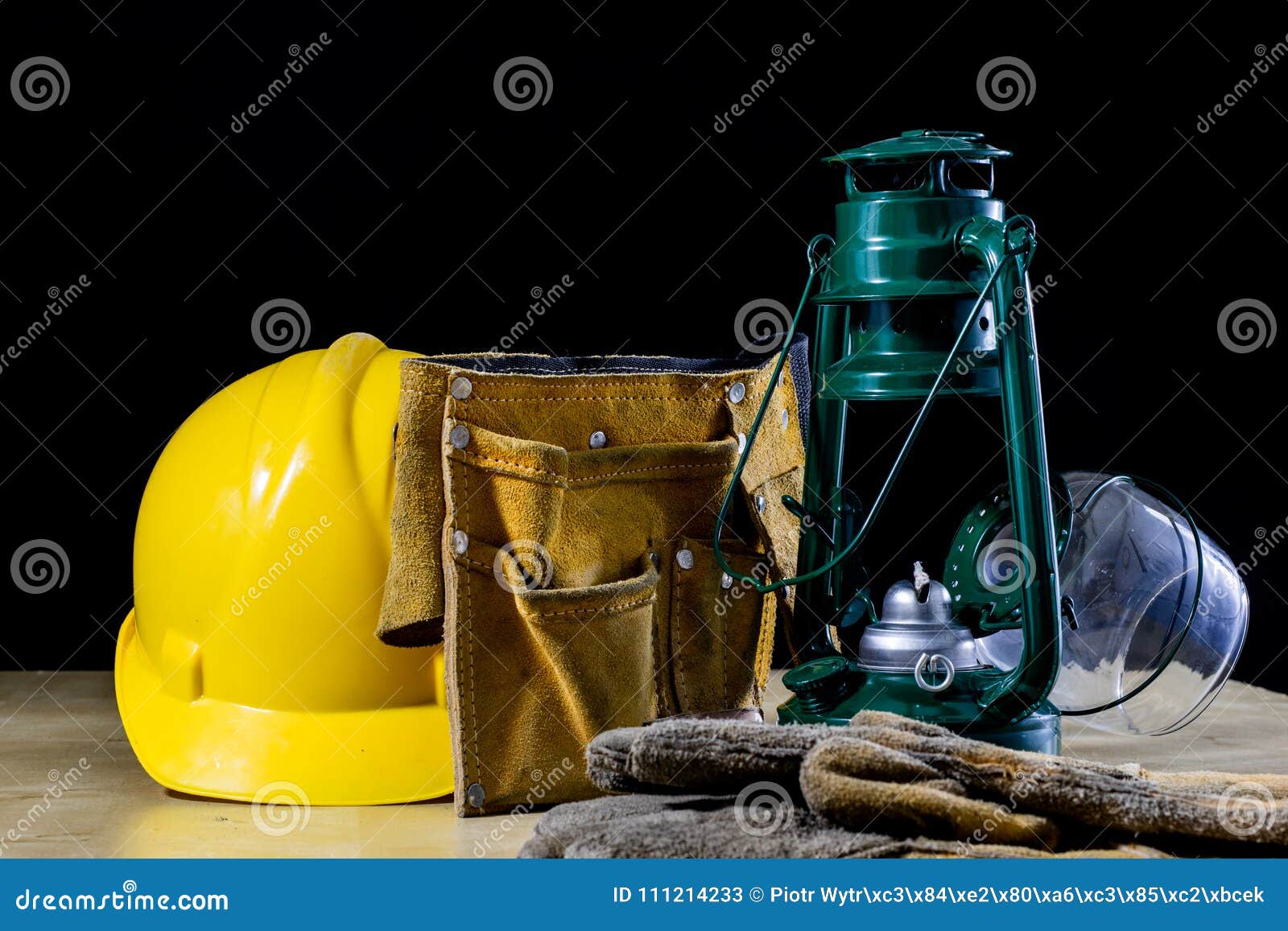 oil lamp, helmet and shoes on a wooden workshop table. worker& x27;s