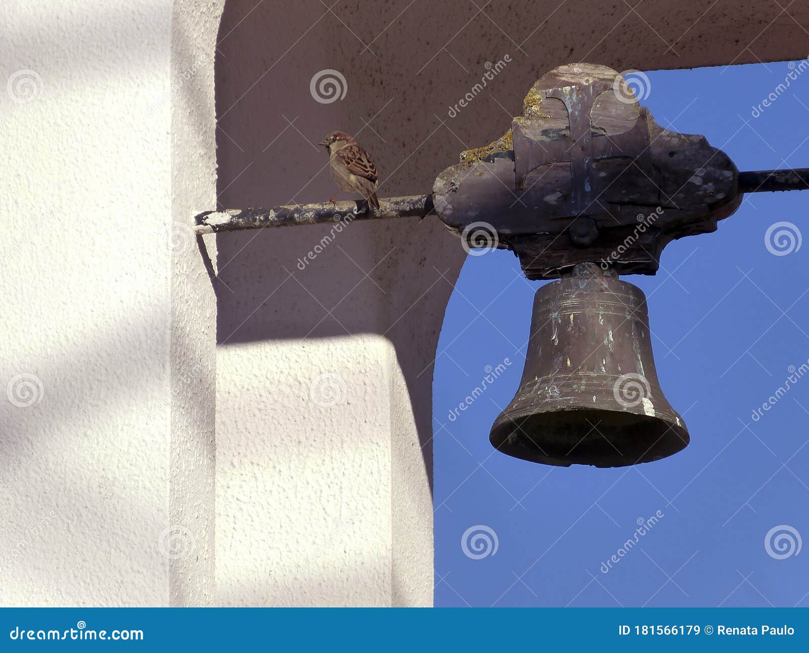 Oiseau dans la cloche de l'église. Seul l'oiseau a atterri dans la vieille cloche de l'église avec un ciel propre