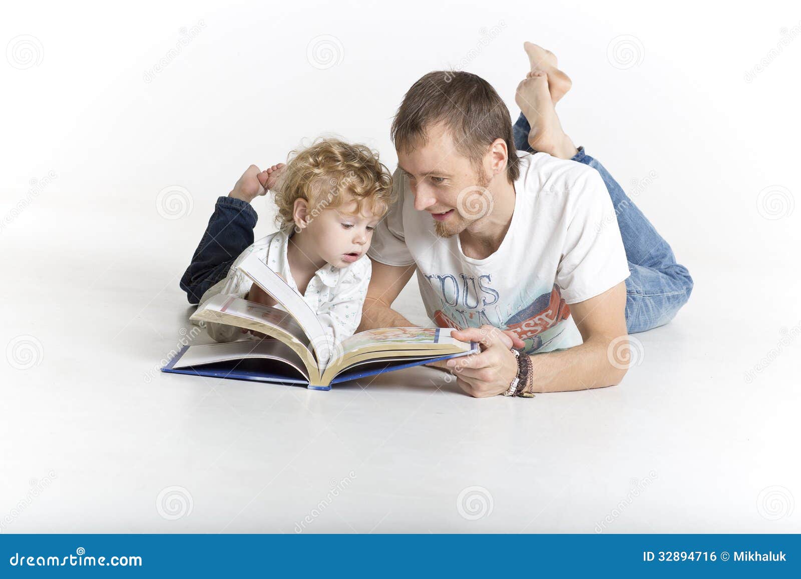 Помогла сыну читать. Отец и сын за чтением книжки. Папа читает сыну. Папа читает сыну книгу. Фотосессия с сыночком с книгами.