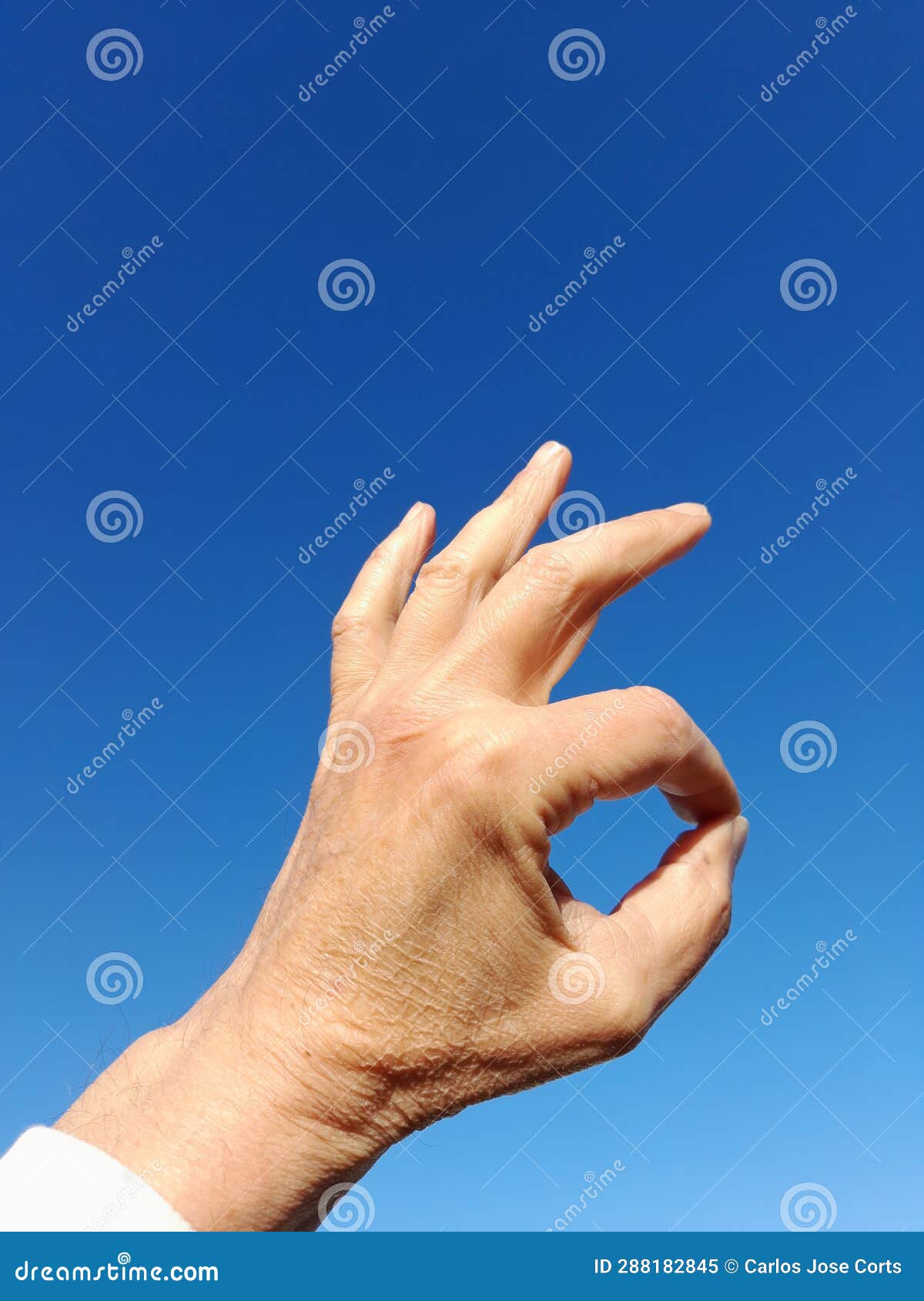 the okay gesture. is to unite the thumb and the index finger and the other straight ones with blue sky