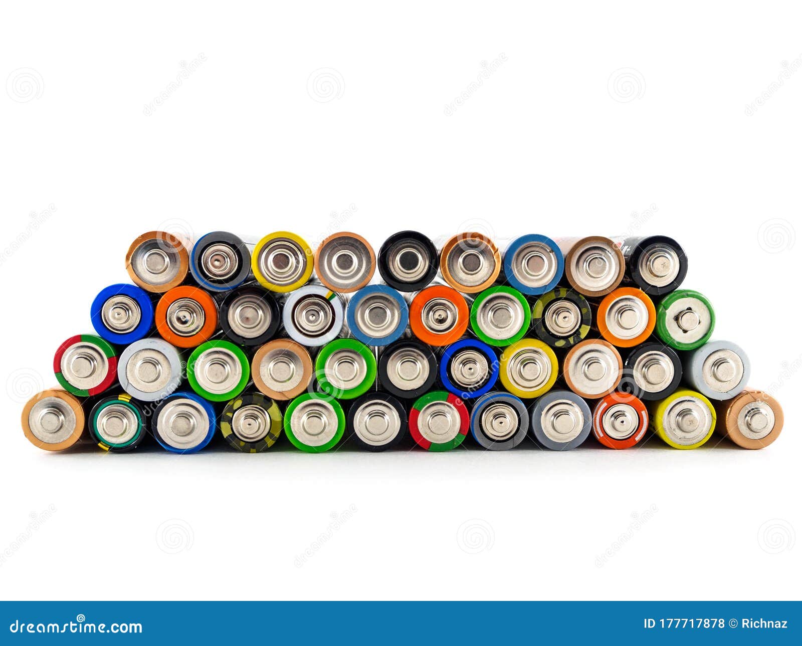 old aa batteries of different colors are stacked in a pyramid. batteries on white background