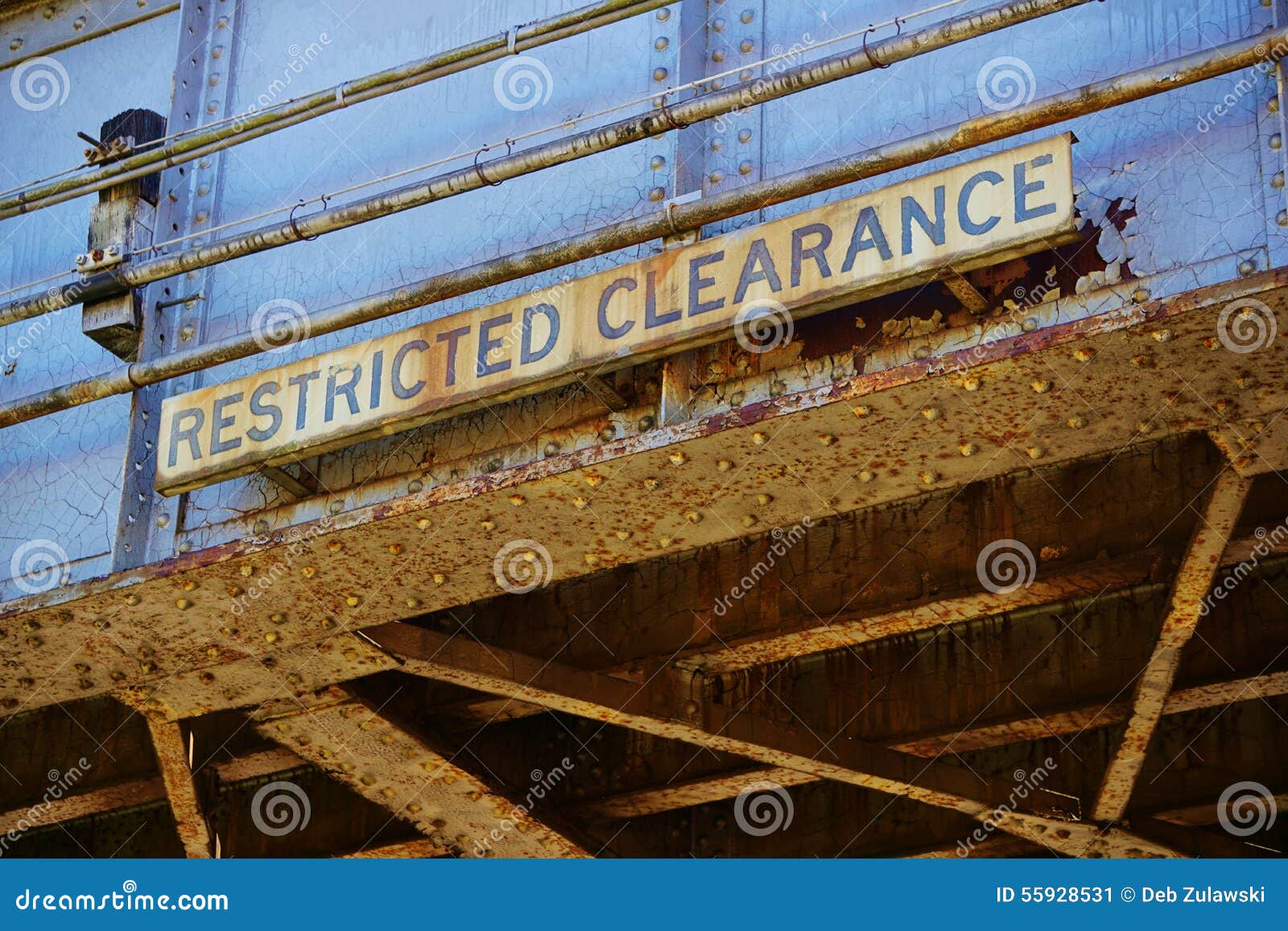 old abandoned rusted train overpass with restricted clearance sign