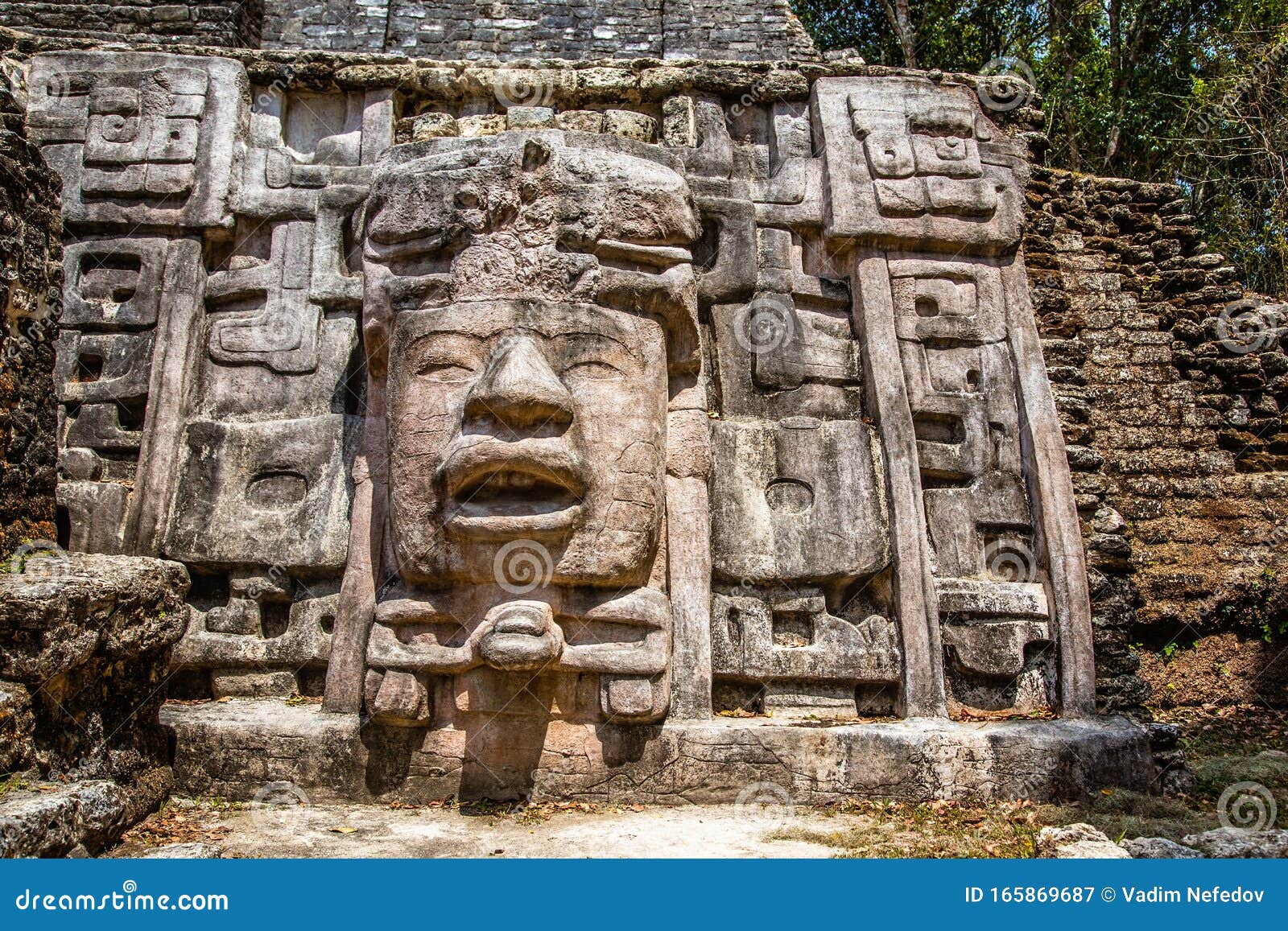 old ancient stone mayan pre-columbian civilization carved face and ornamen88t, lamanai archeological site, orange walk district,