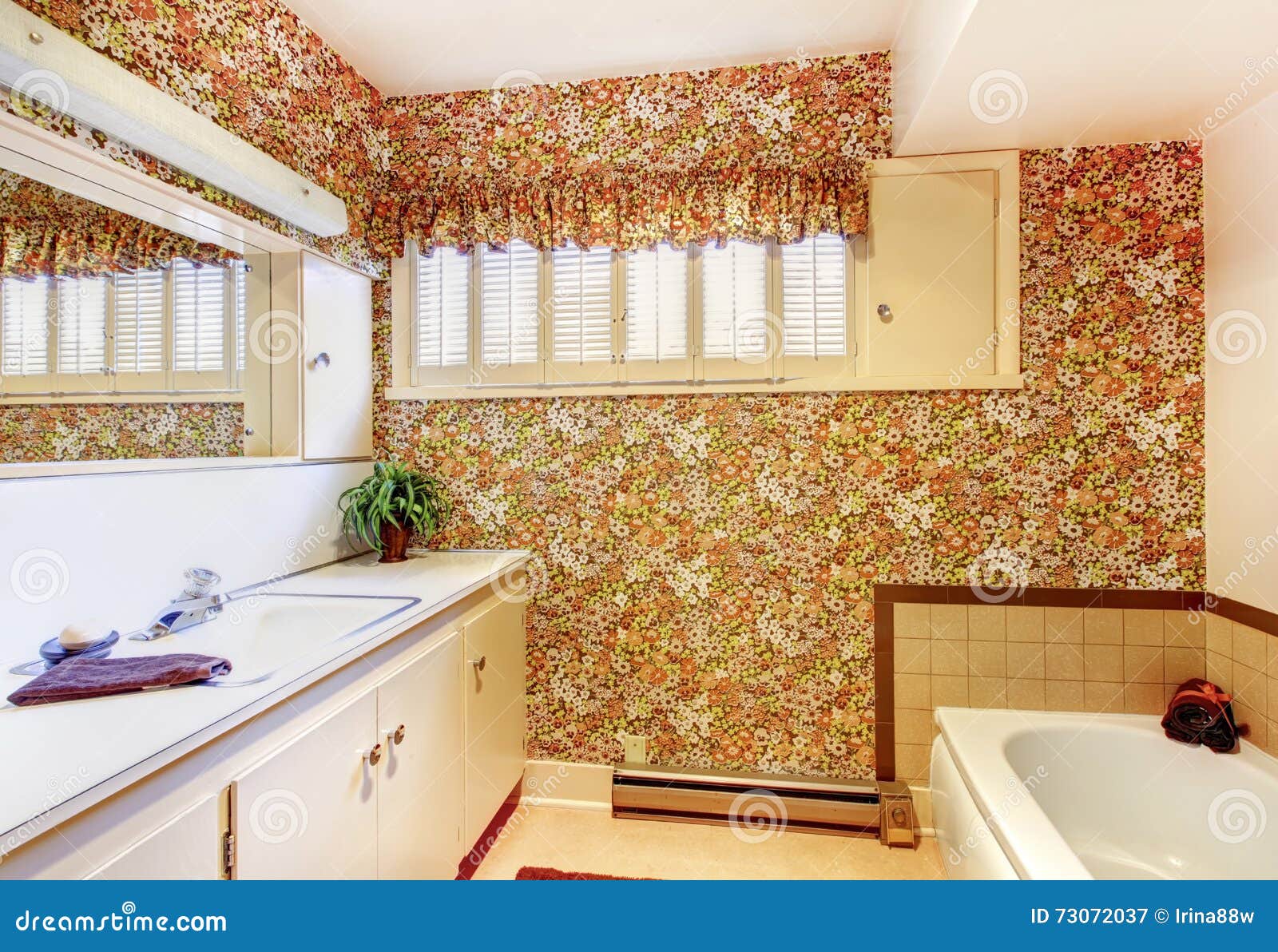 Old Bathroom with Floral Pattern Wallpaper, White Cabinets and B Stock
