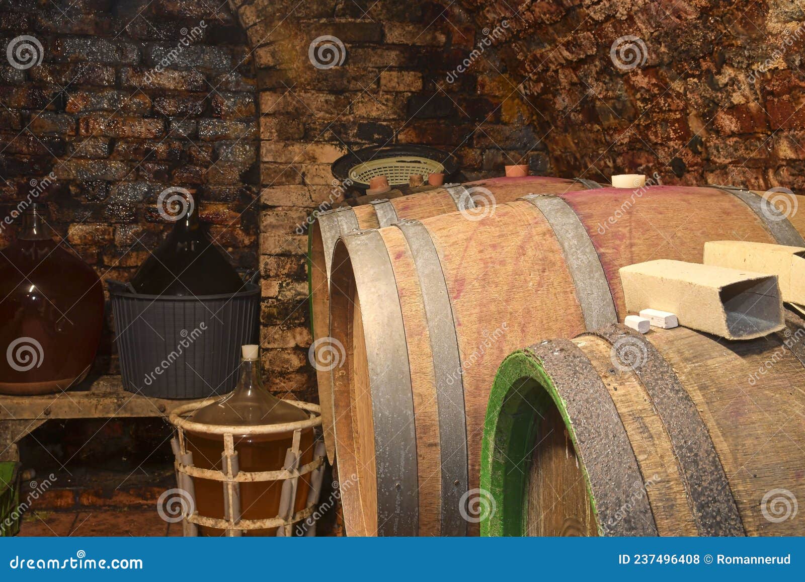 Old Cellar with Demijohns and Wooden Barrels. Making Wine Traditionally