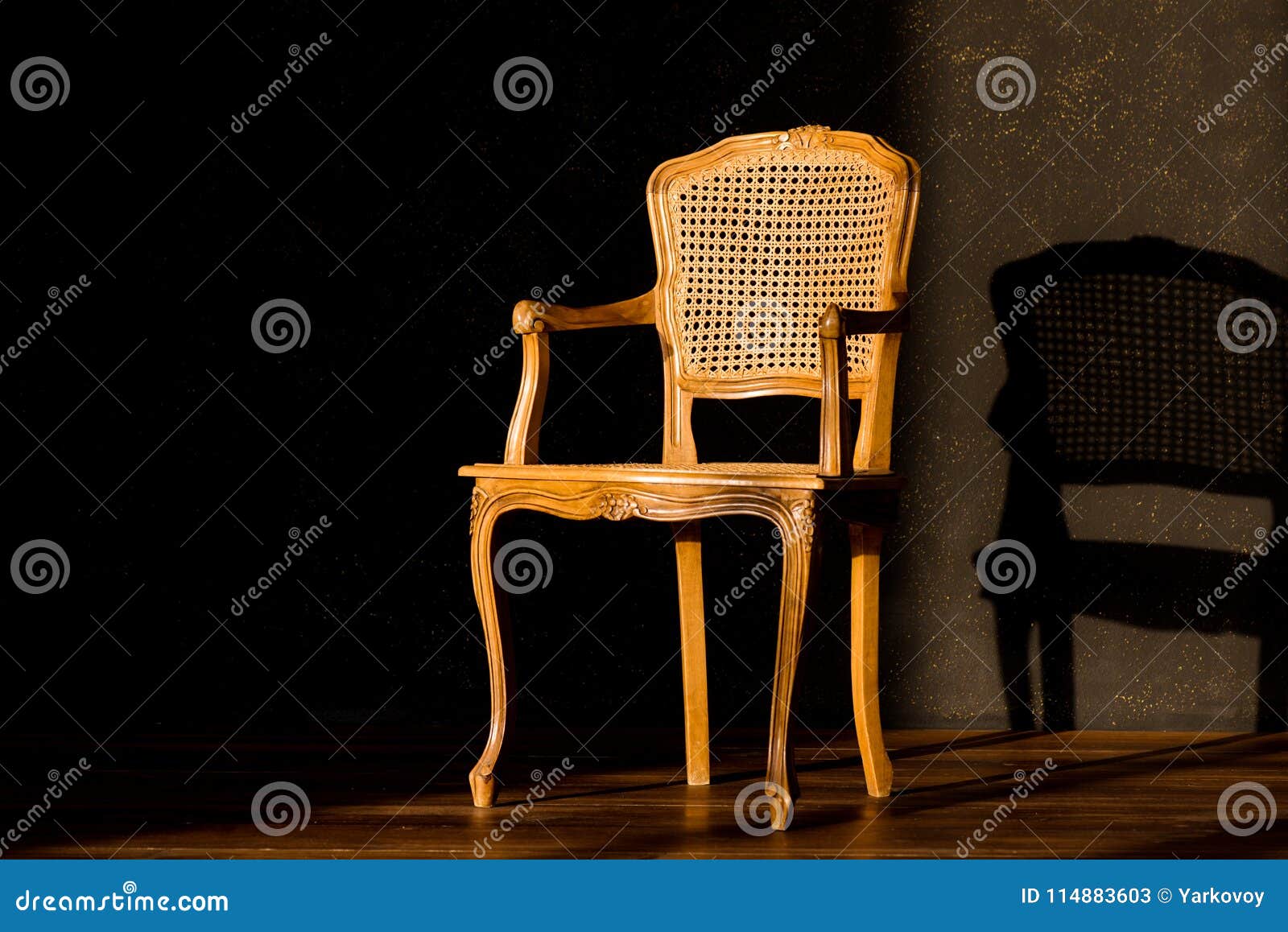 old chair on a black wall background.