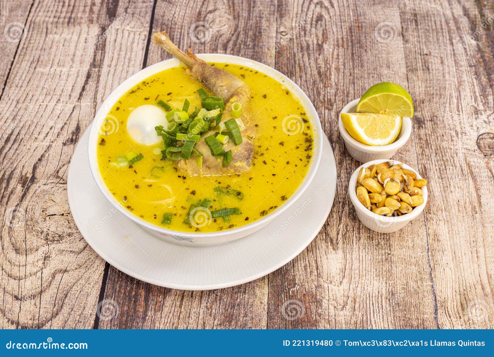 old chicken broth with typical peruvian recipe accompanied by a bit of cancha and slices of lime and lemon