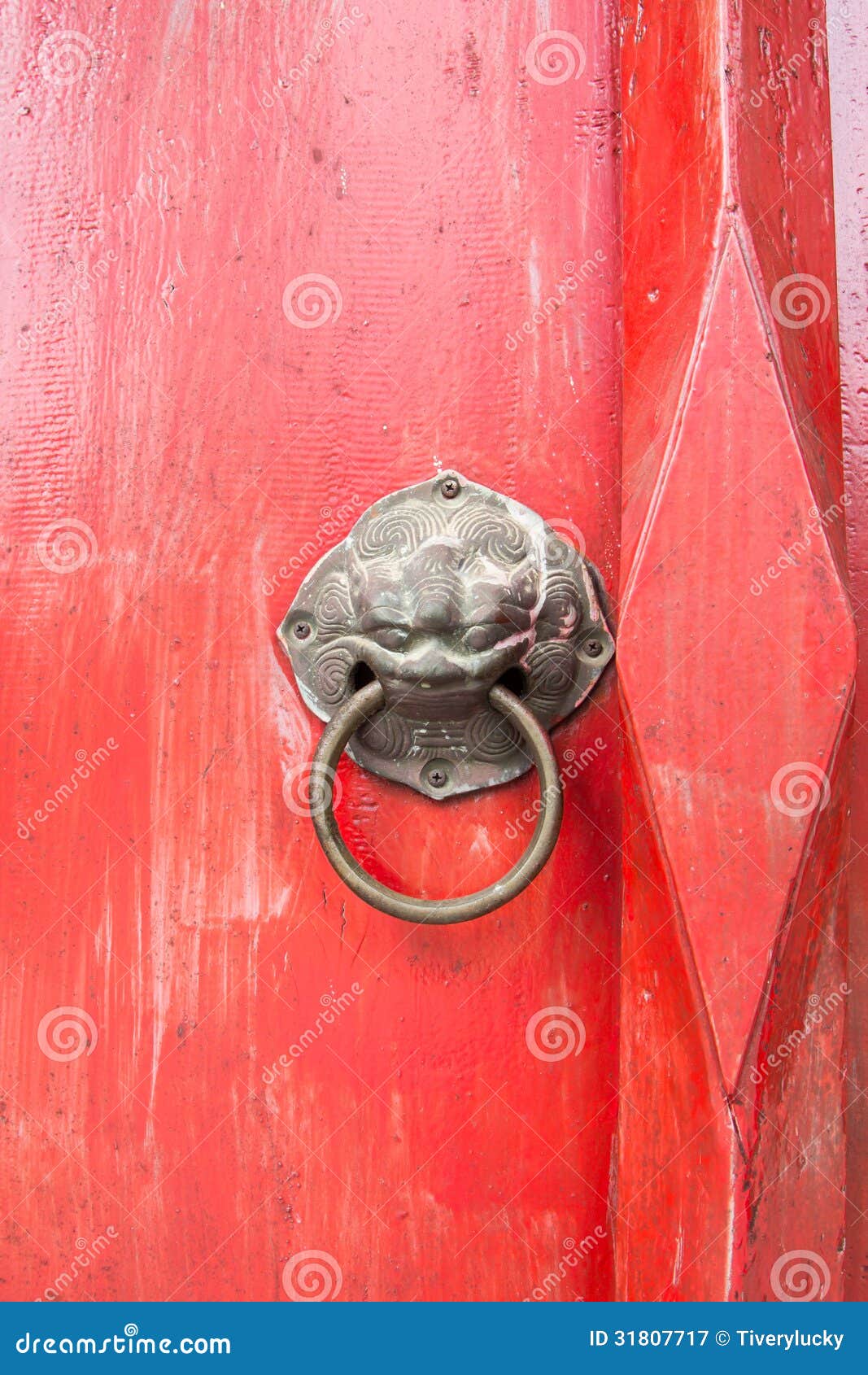 Old chinese door. The door handles are red with lion heads.