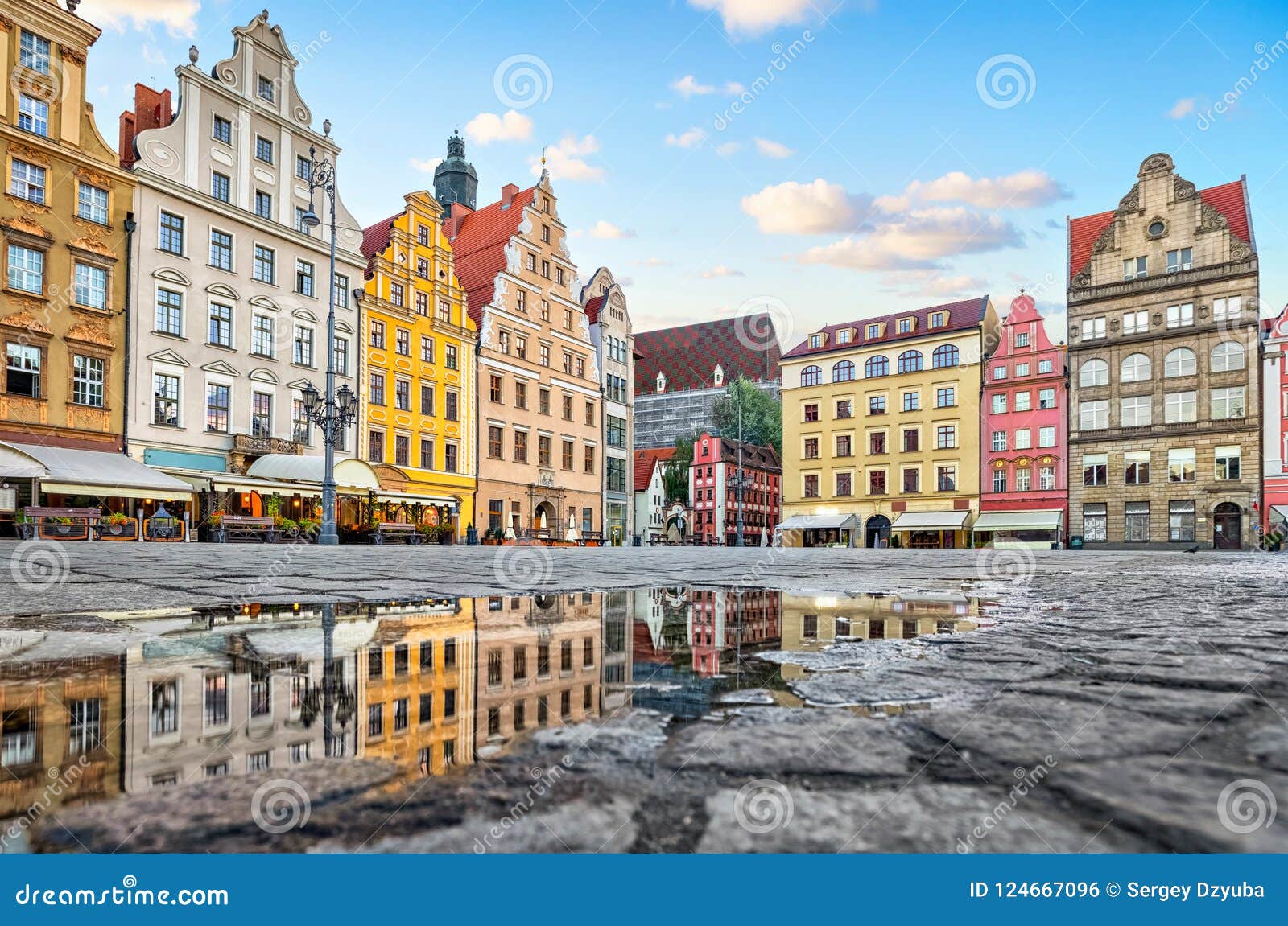 colorful buildings reflecting in a puddle on rynek square in wroclaw