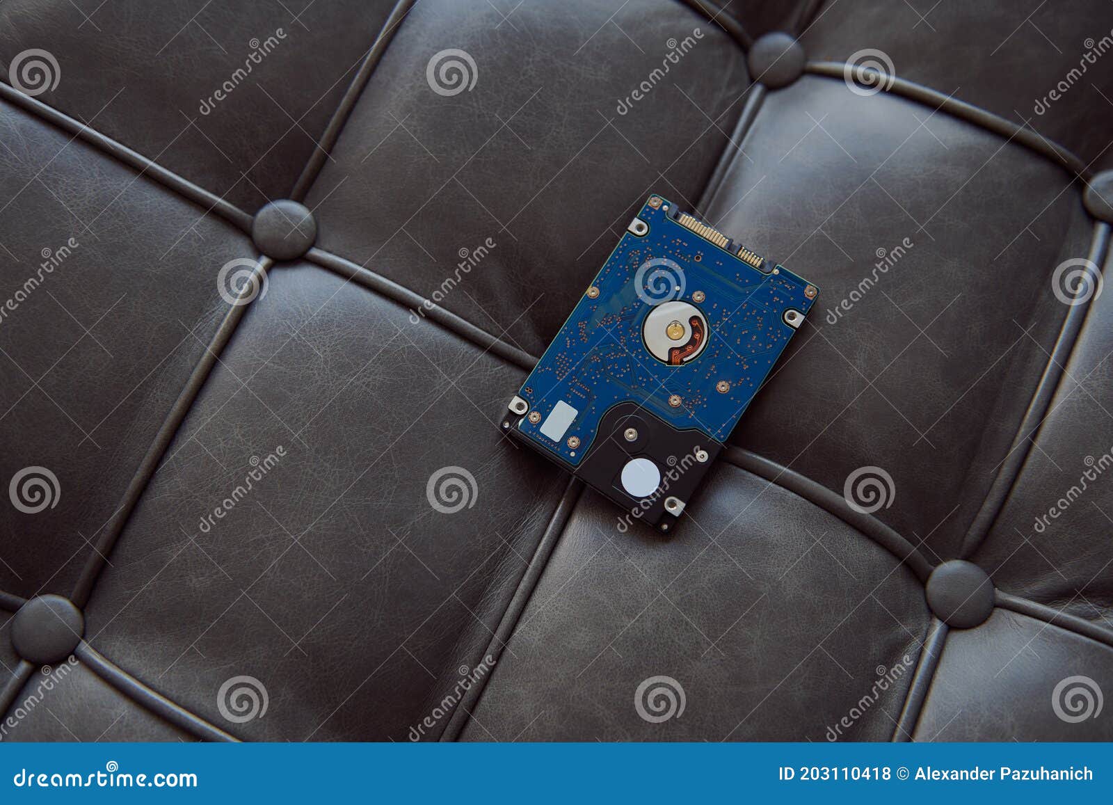 Hard Disk Drive Laying on the Grey Leather Sofa. Stock Photo Image of