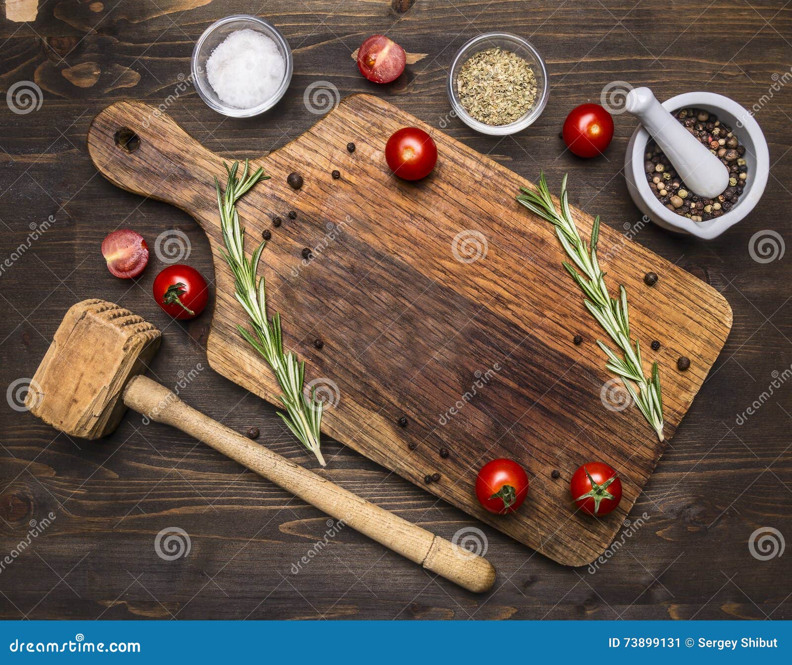 old cutting board with spices and herbs for cooking meat with cherry tomatoes and a hammer meat place for text,frame