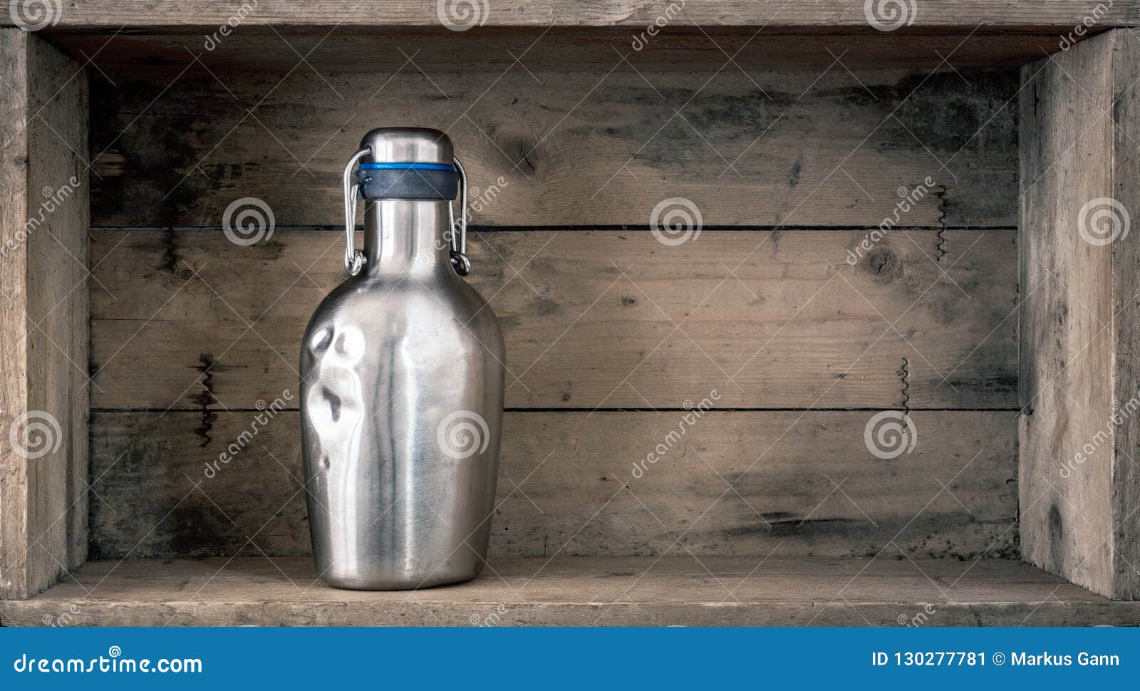 old dented metal bottle on wooden background