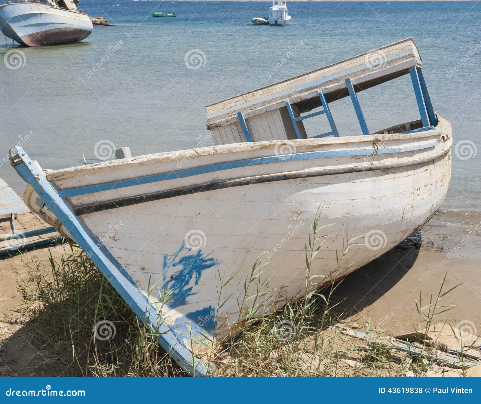 Old derelict boat abandoned on beach. Old derelict small boat abandoned on beach by coast