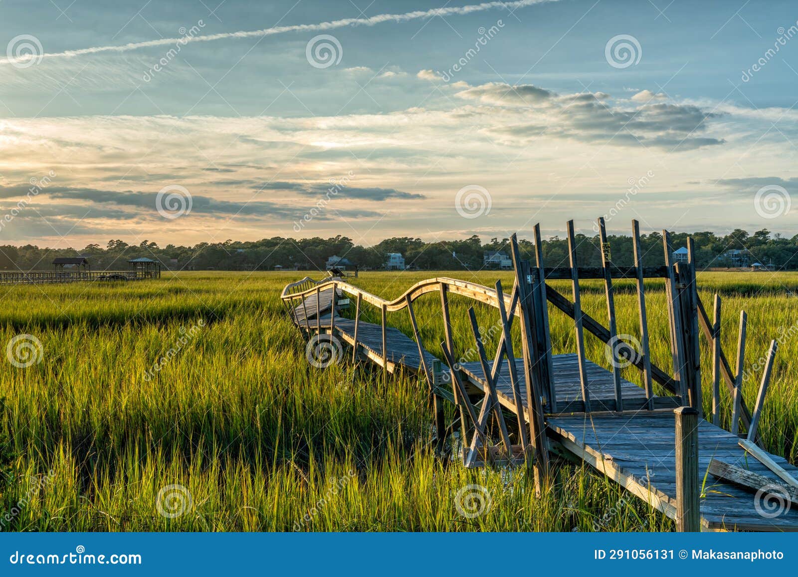 old dilapidated wooden dock in the marshgrass and inlet of palweys island in south carolina