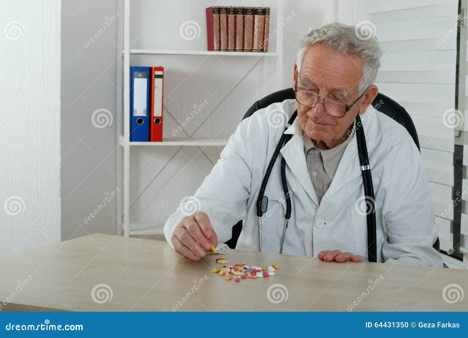 old doctor observe colorfully pills in consulting room