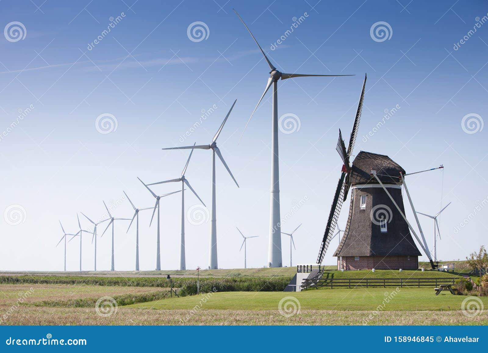 Old Dutch Windmill And Modern Wind Turbines Against Blue ...