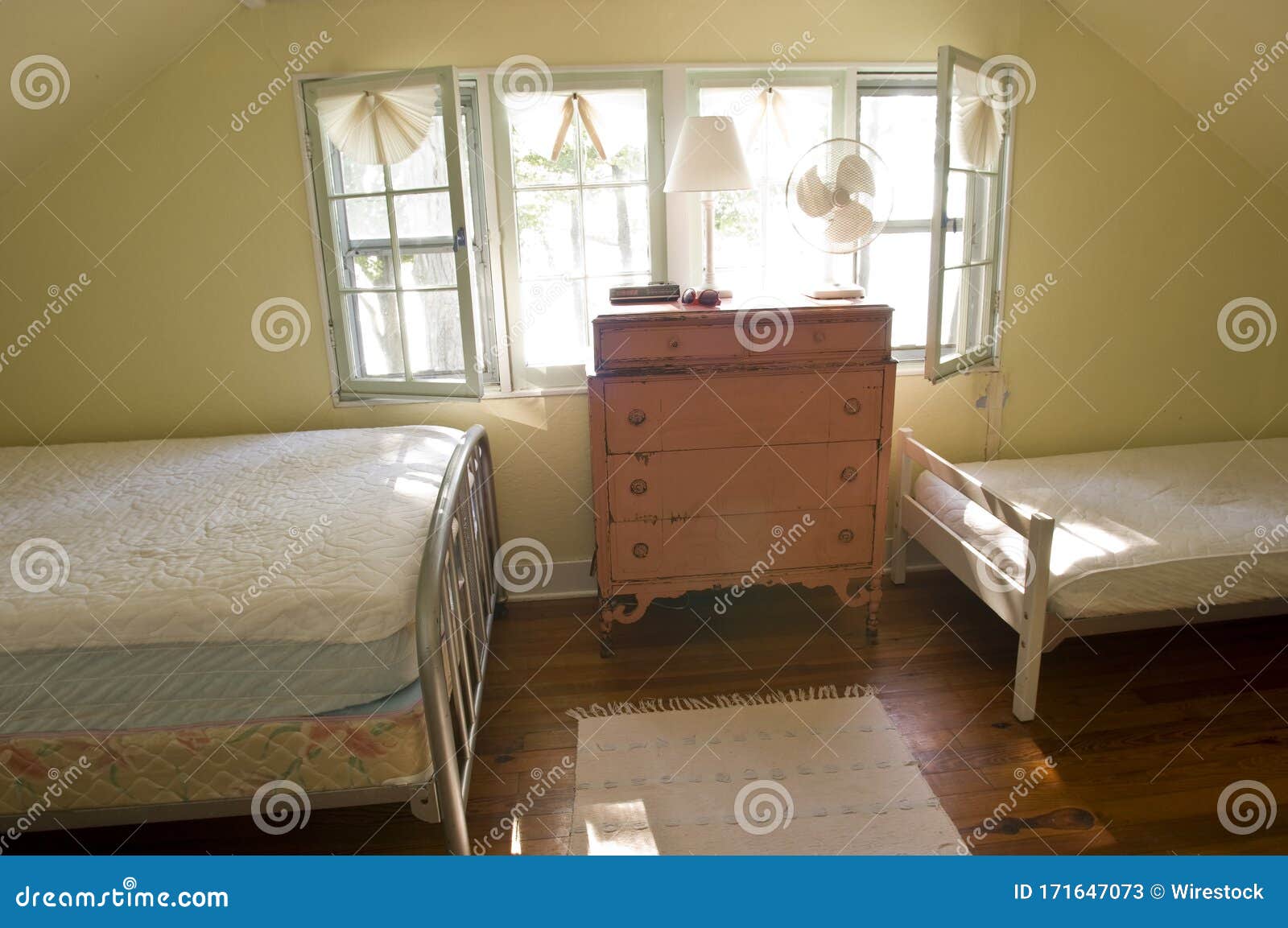 Old Fashioned Bedroom with Two Beds and a Cupboard Under the Sunlight