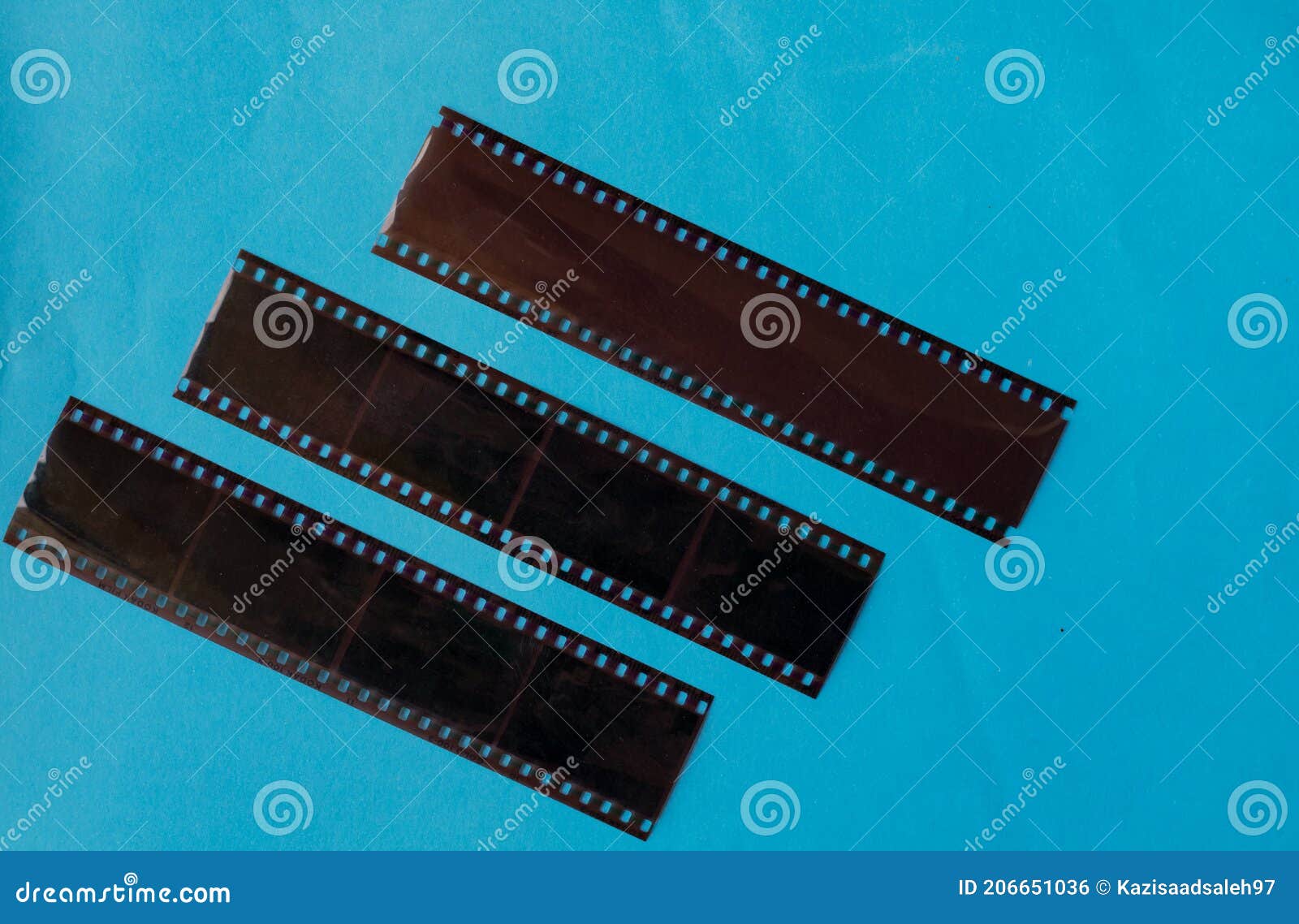 Old Film Negatives on a Plain Blue Colour Background Stock Photo