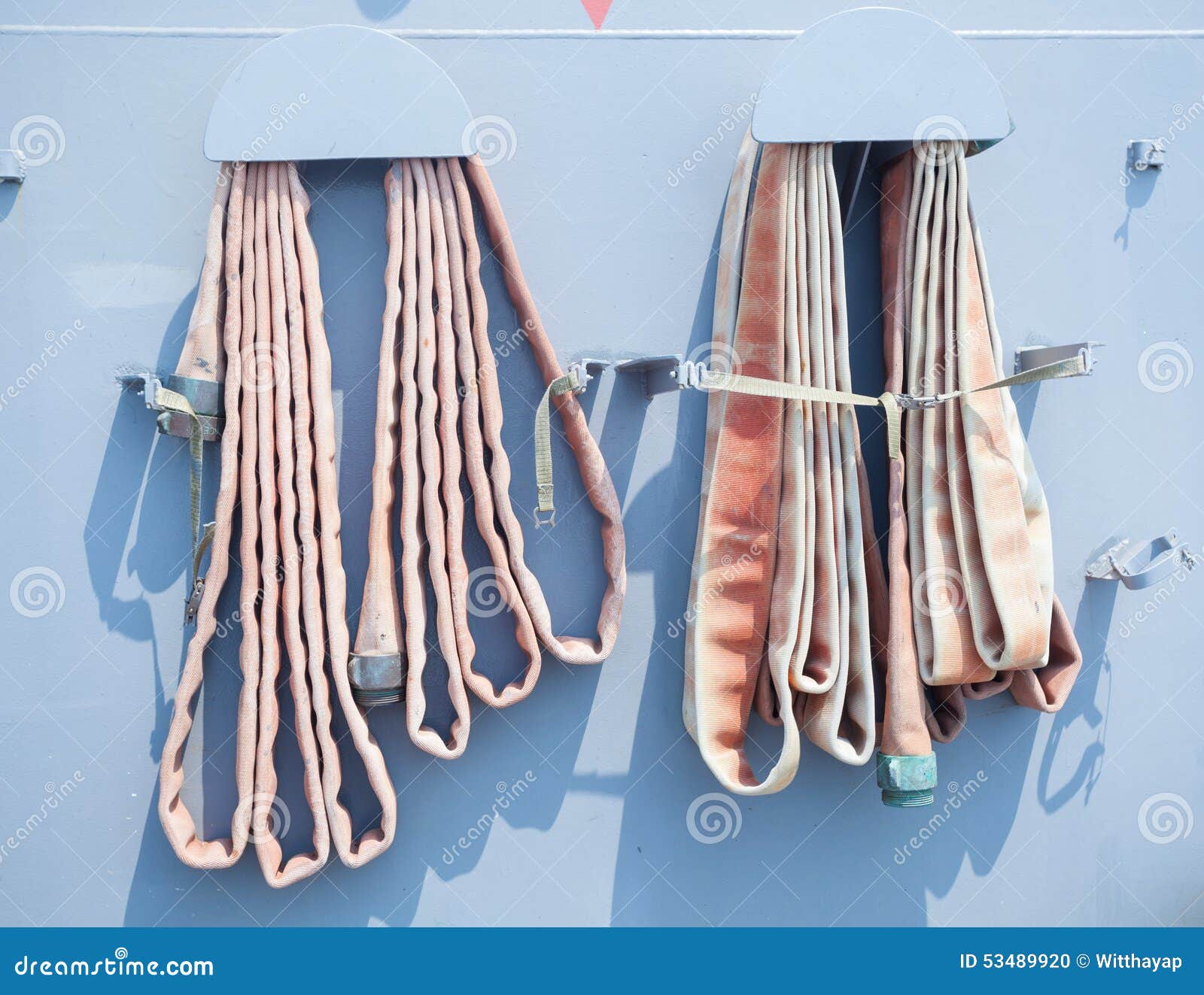 Old fire hose on blue wall stock photo. Image of blue 53489920