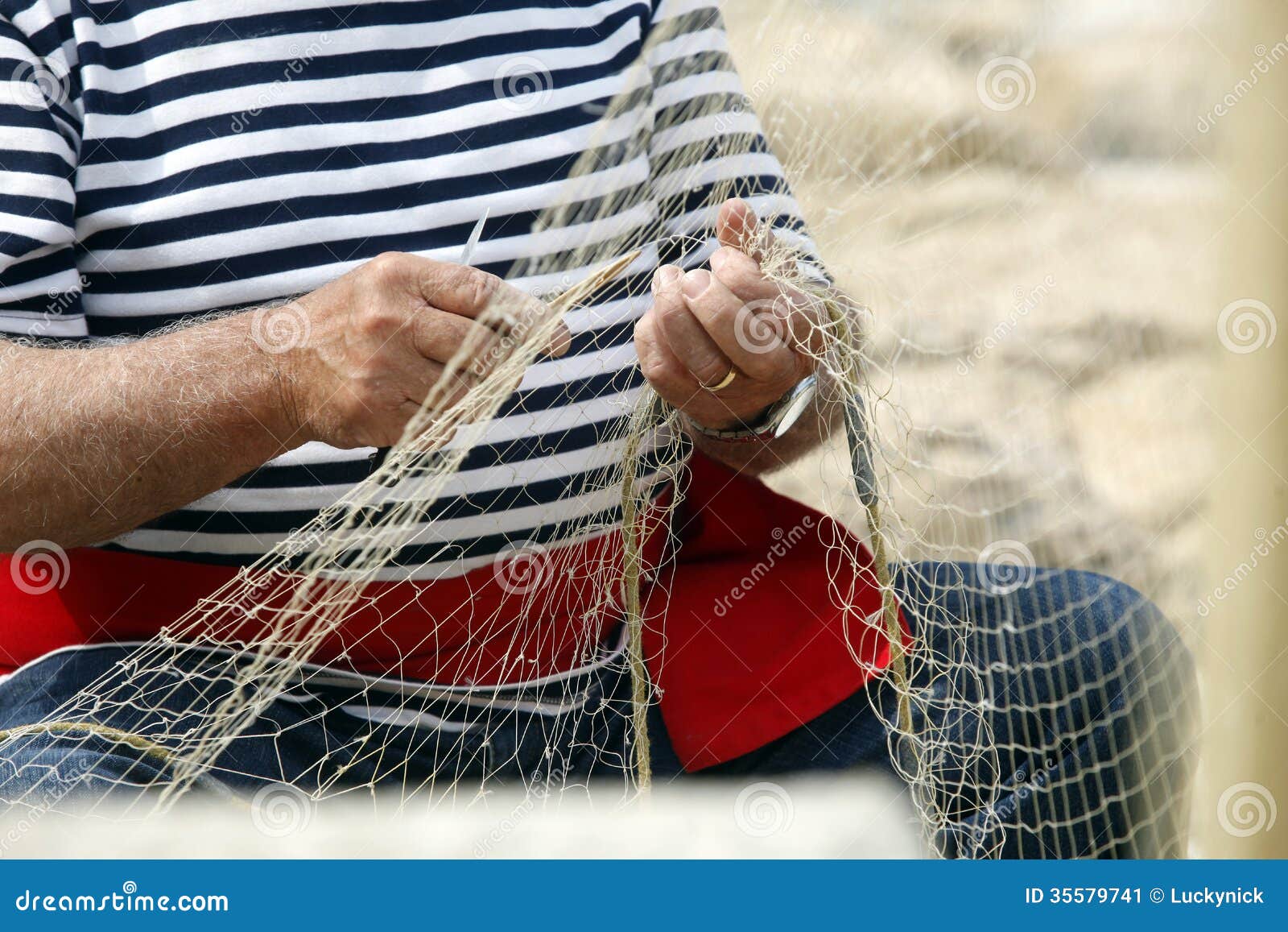 old fisherman mending nets