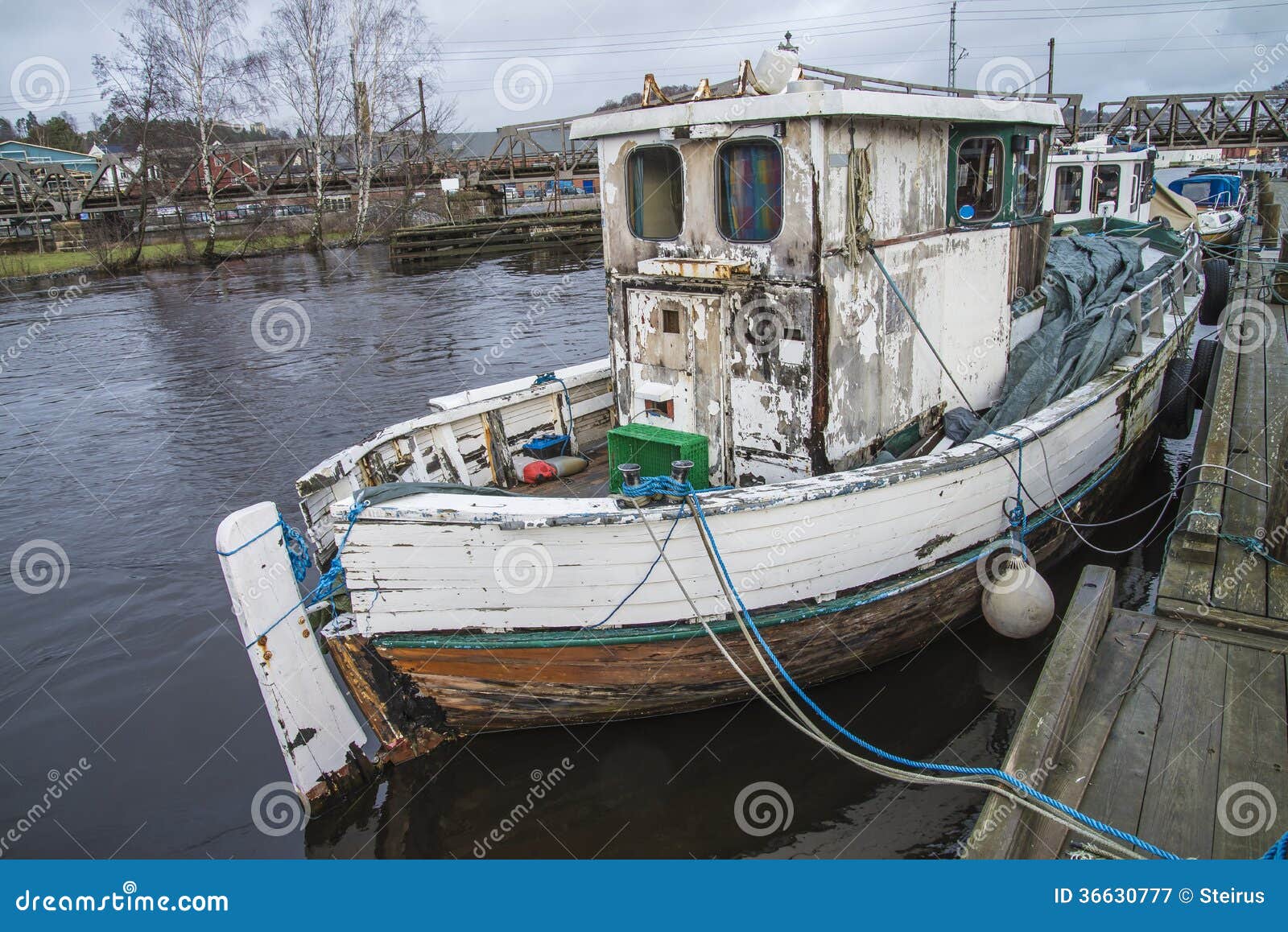 old fishing boat moored on the river pier stock image