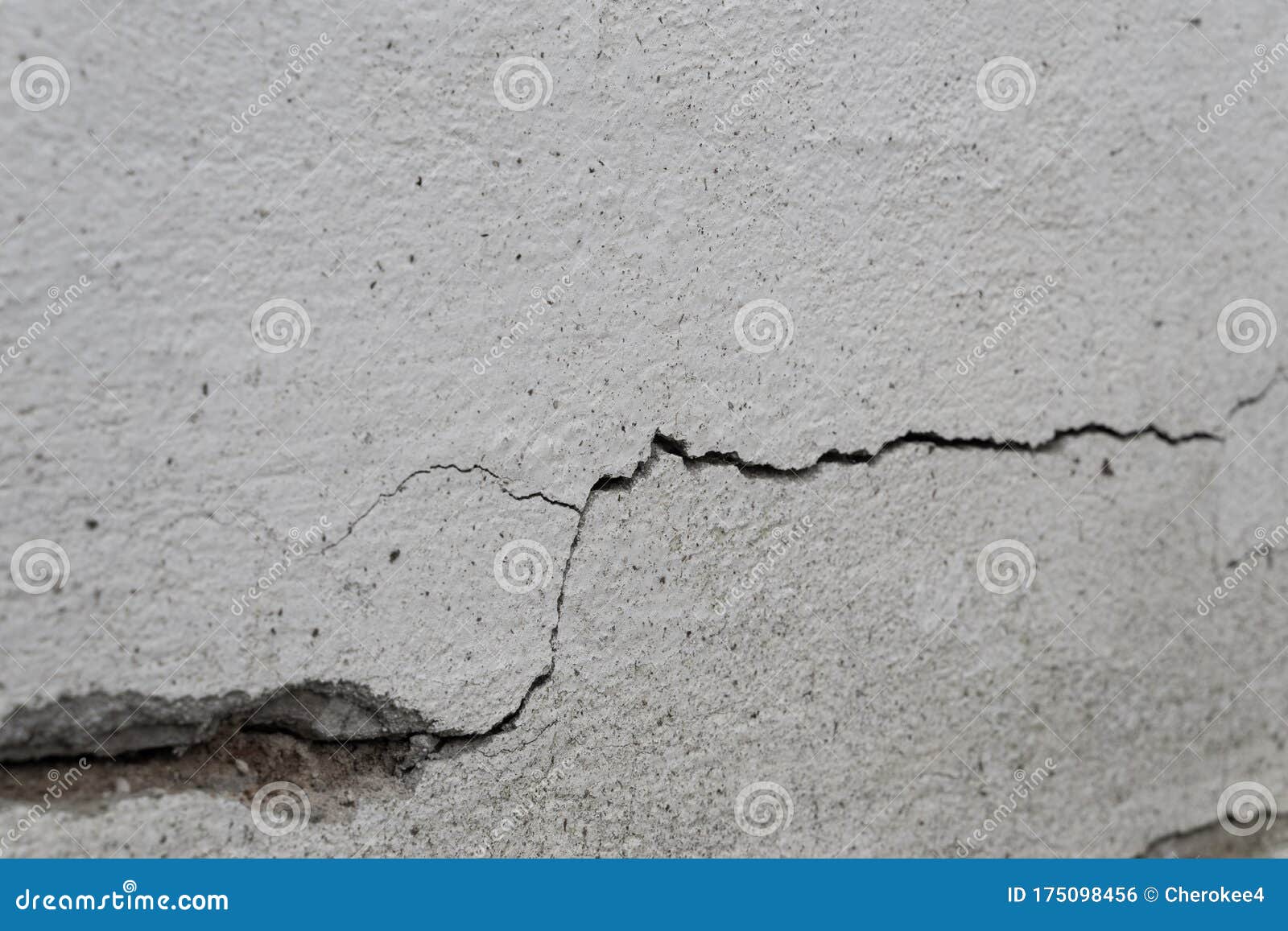 old foundation and plaster wall with cracks. building requiring repair closeup.