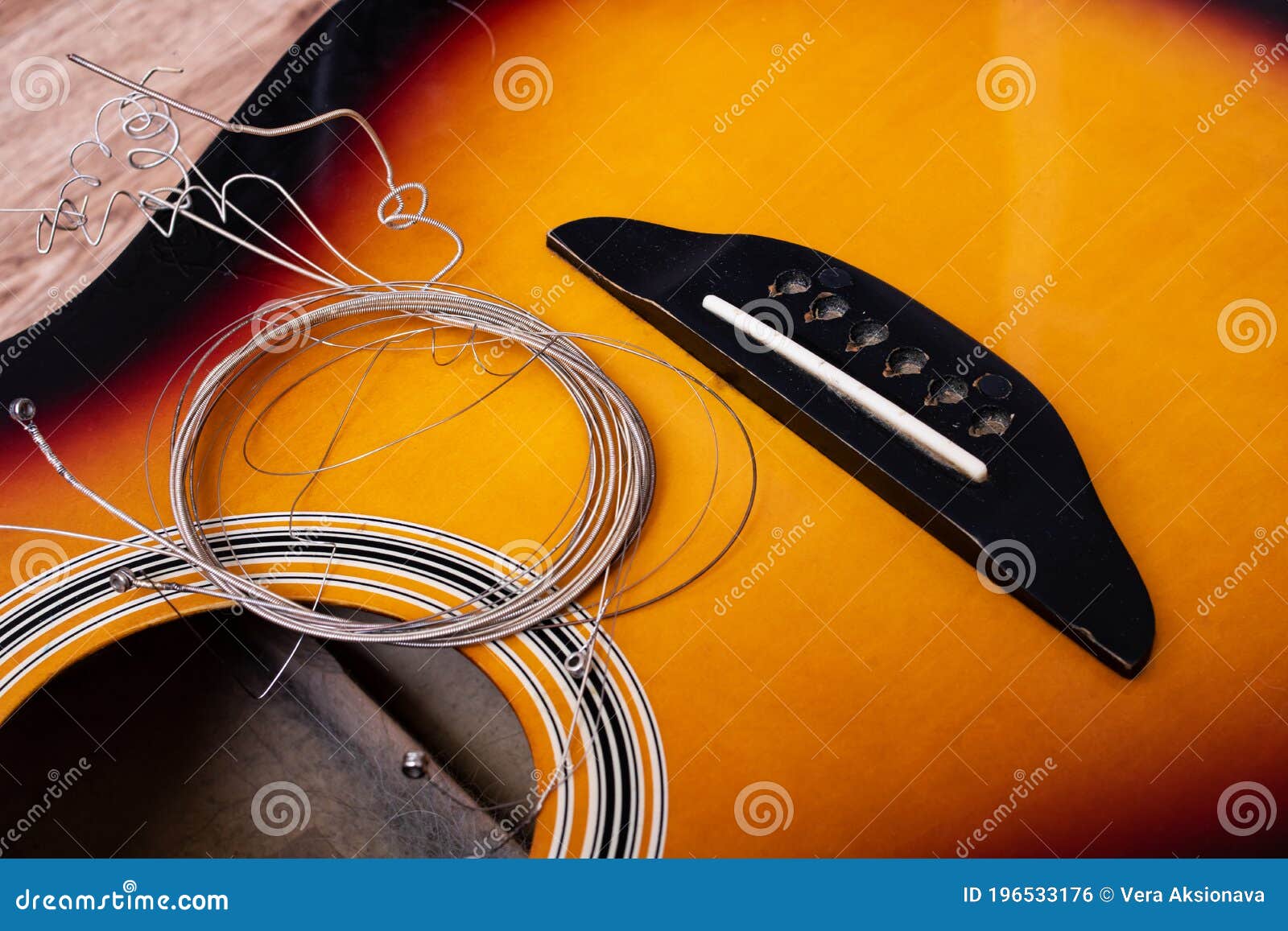 Old Guitar and Strings Closeup on Wooden Background Stock Photo Image