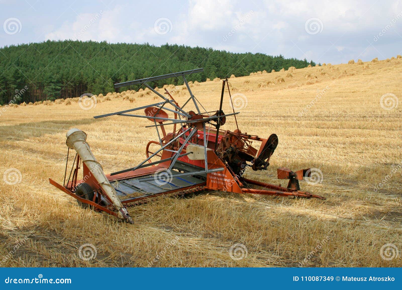 old hay rake reaper-binder - rustic, oldfashioned farm equipment, used for field works during harvest season.