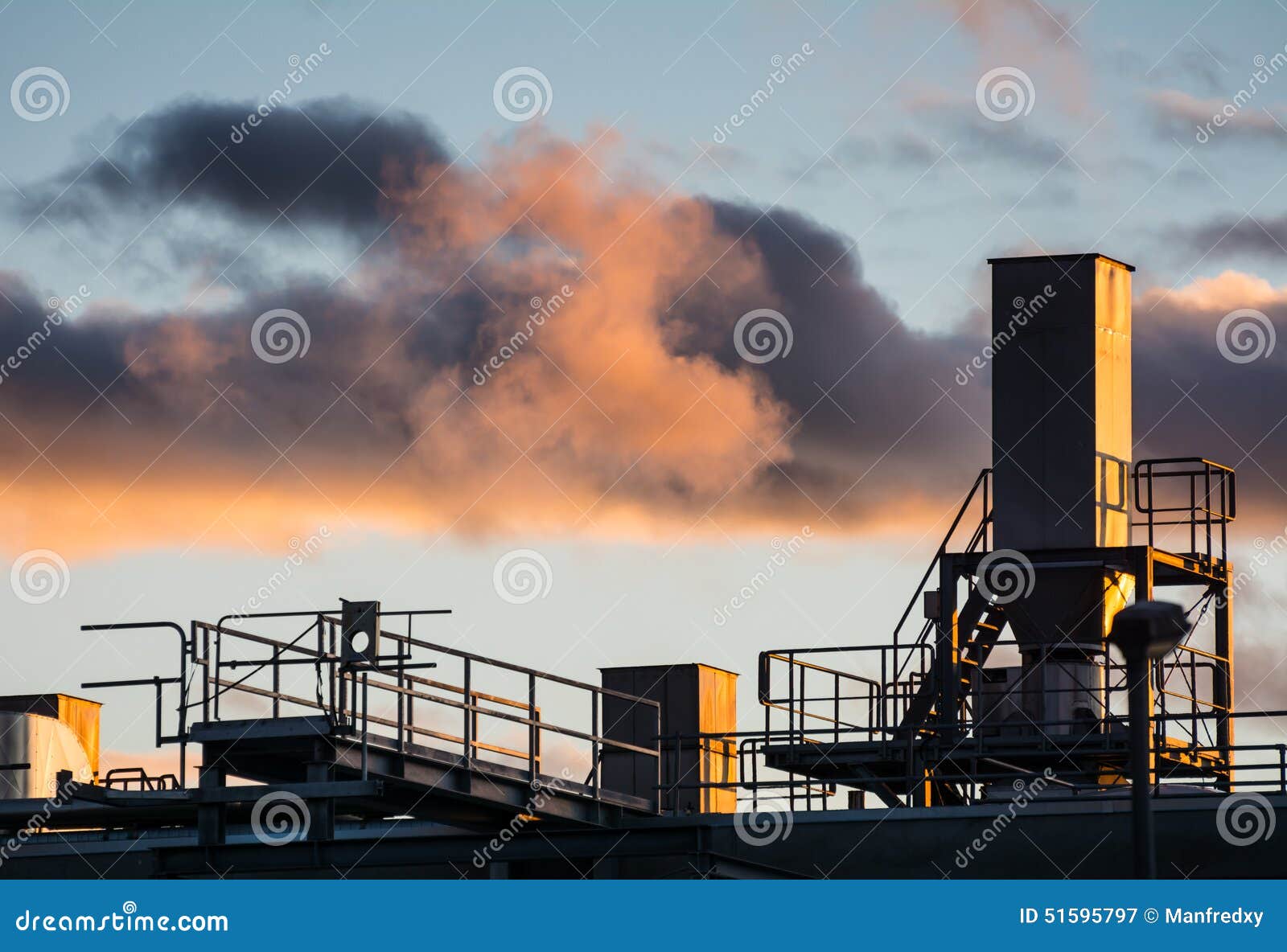 Old industrial site with dark clouds in the evening sky.