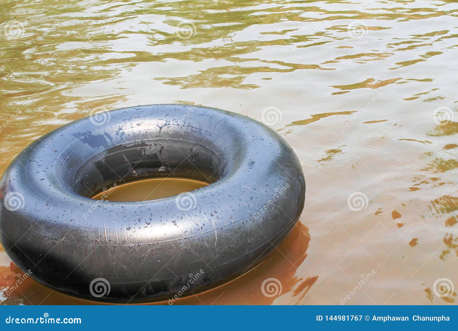 Old Inner Tubes with Water Drops and Reflection from the Sun Floating