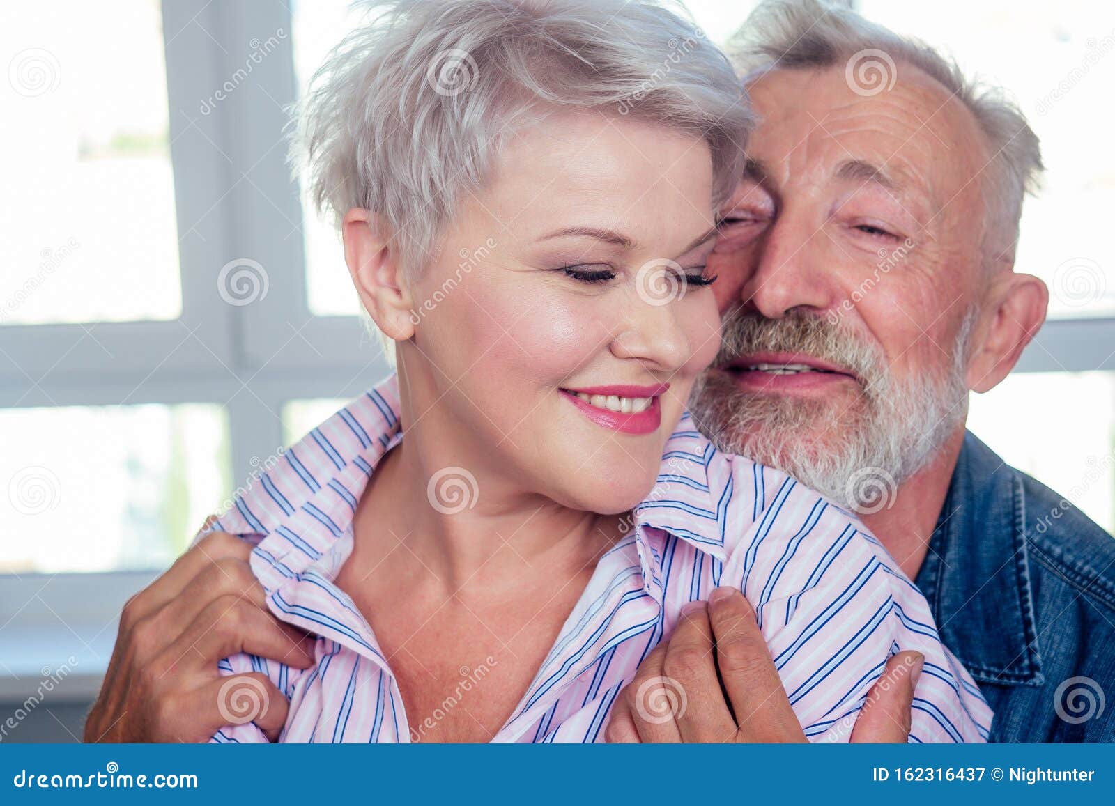 Old Man Hard Hugging Her Young Wife with Blonde Hairstyle and Red Lipstick Stock Image