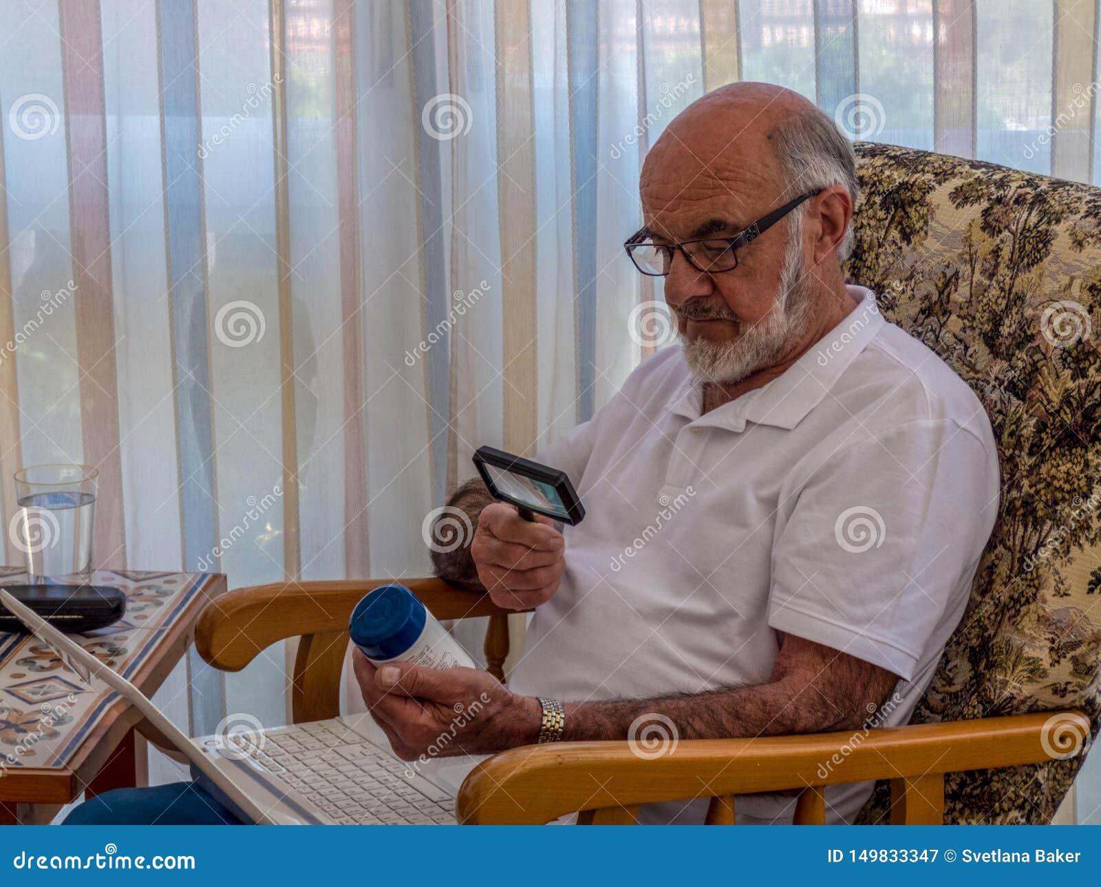 old man  with magnifying glass reading on the jar with vitamines