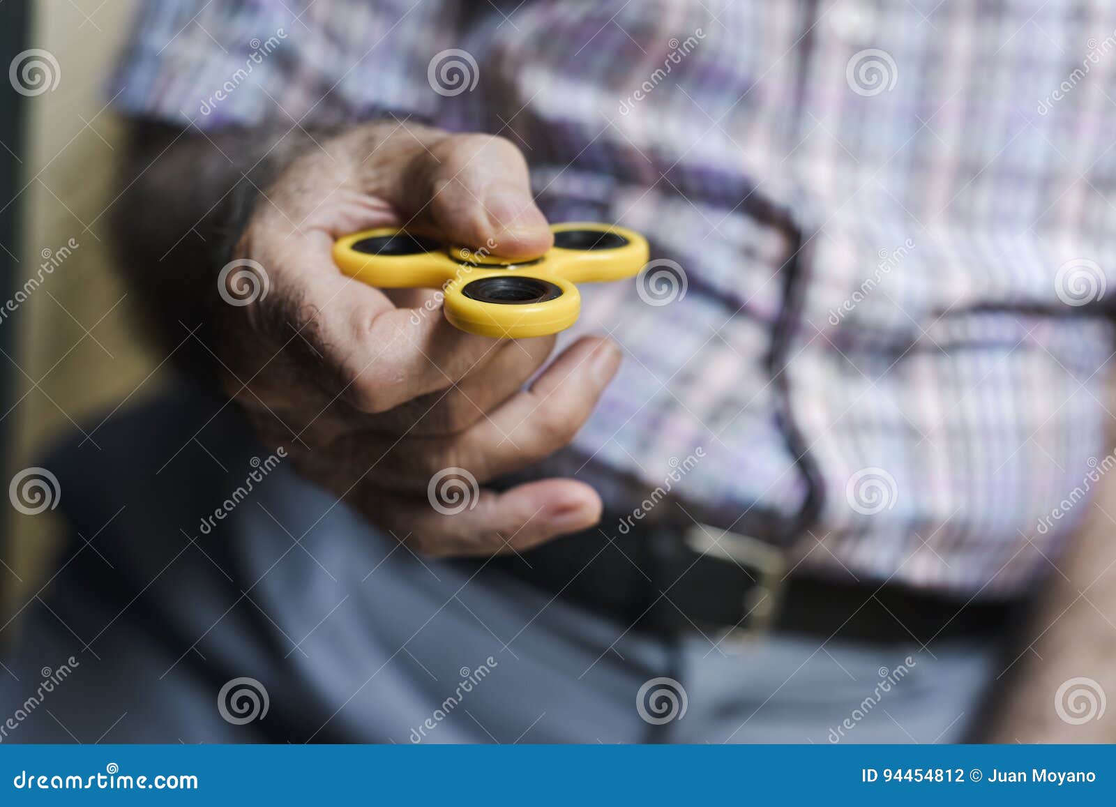 old man playing with a fidget spinner