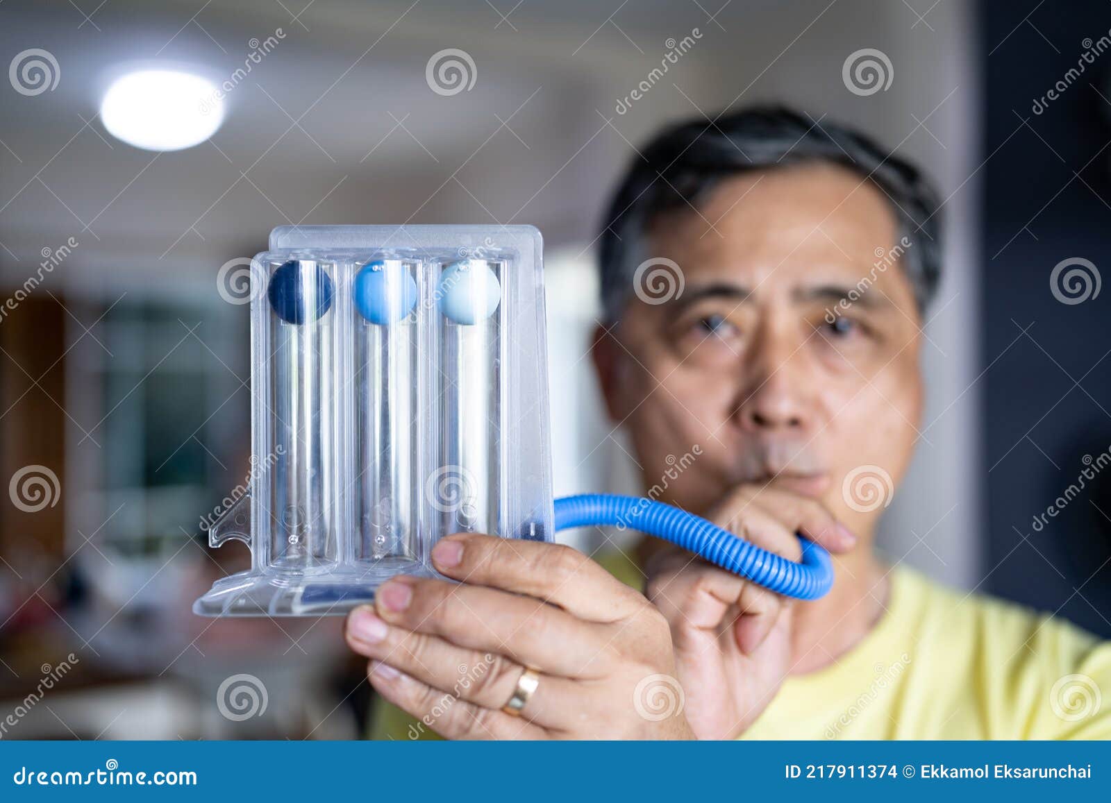 Old Man Uses a Triball Incentive Spirometer for Check His Lung